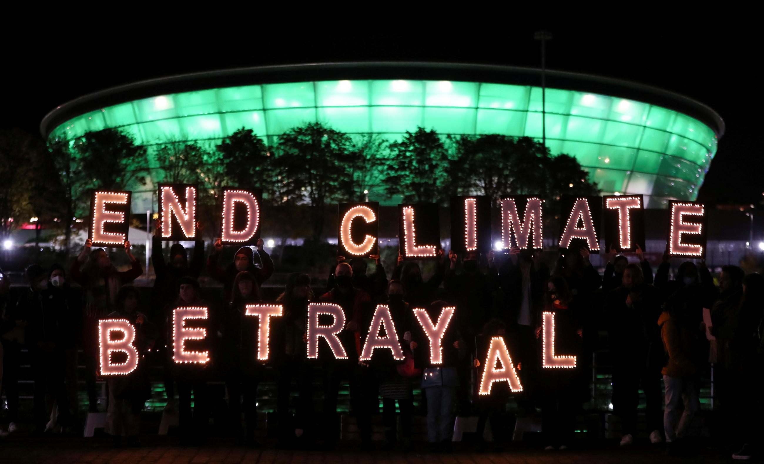 Climate youth activists display a message during a protest opposite the venue for the UN Climate Change Conference (COP26) in Glasgow, Scotland, Britain November 2, 202