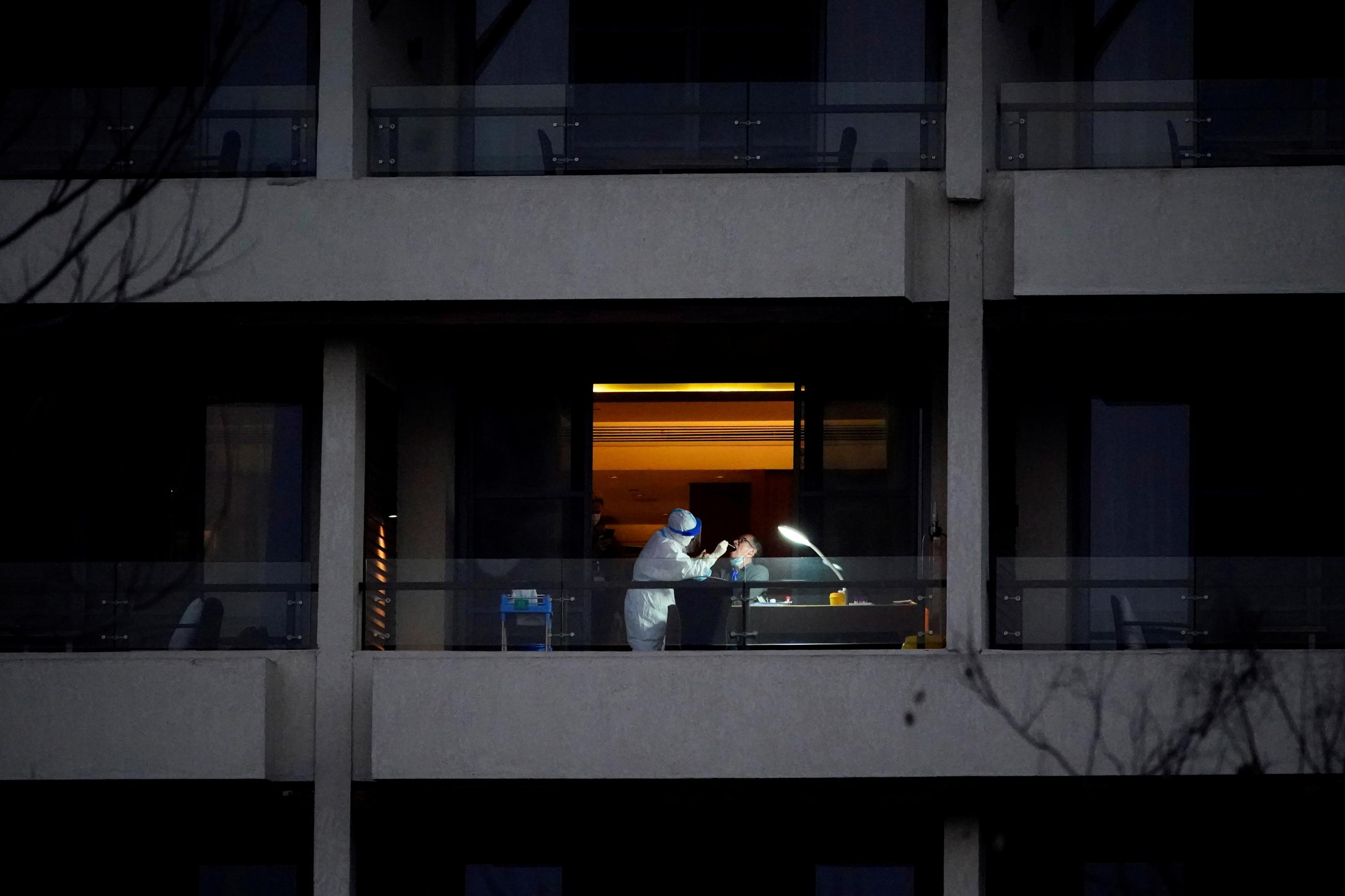 WHO virus expert Peter Ben Embarek, a member of the World Health Organisation (WHO) team tasked with investigating the origins of the coronavirus disease (COVID-19), receives a swab test on the balcony of a hotel in Wuhan, Hubei province, China February 3, 2021. 