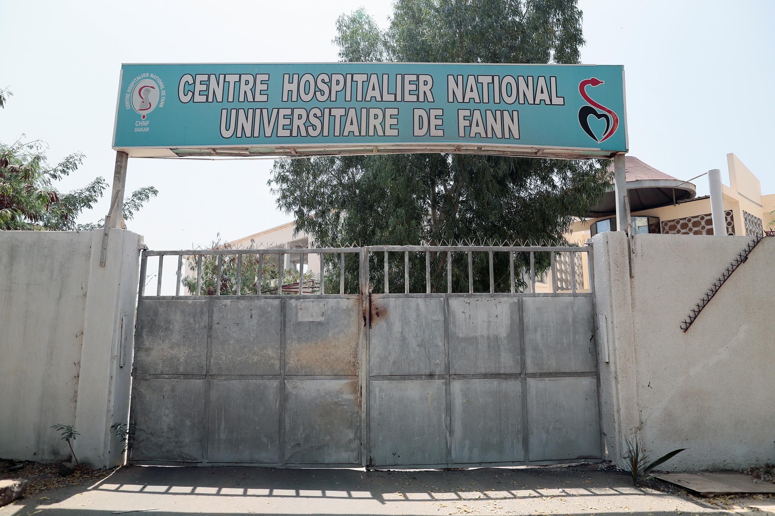 A concrete wall and heavy, closed gate surrounds the Centre Hospitalier National Universitaire de Fann (Fann Hospital) in Dakar, Senegal, March 3, 2020.