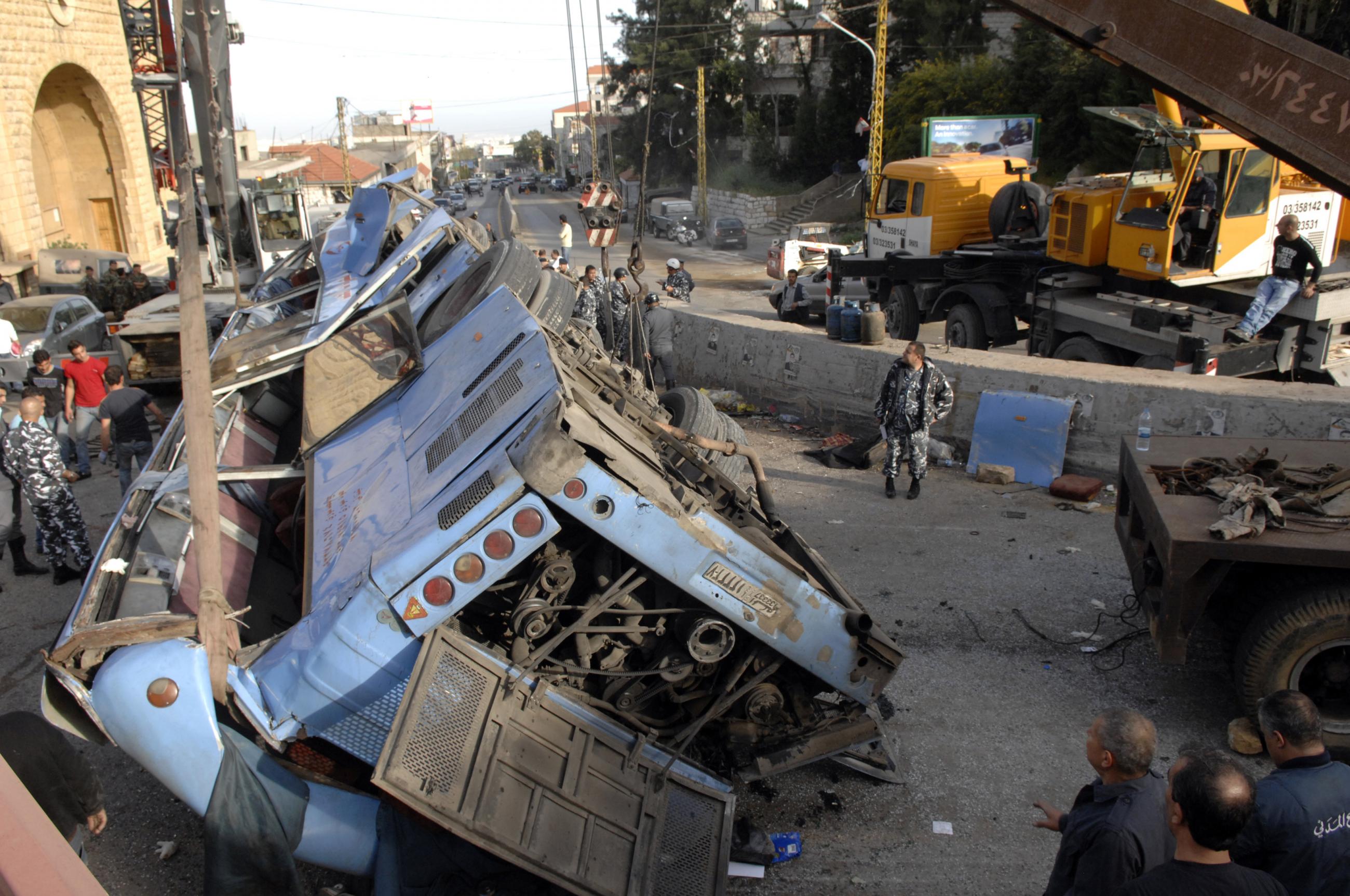 Lebanese policemen inspect the wreckage of a bus that overturned in an accident in Kahale, east Beirut March 15, 2013. 