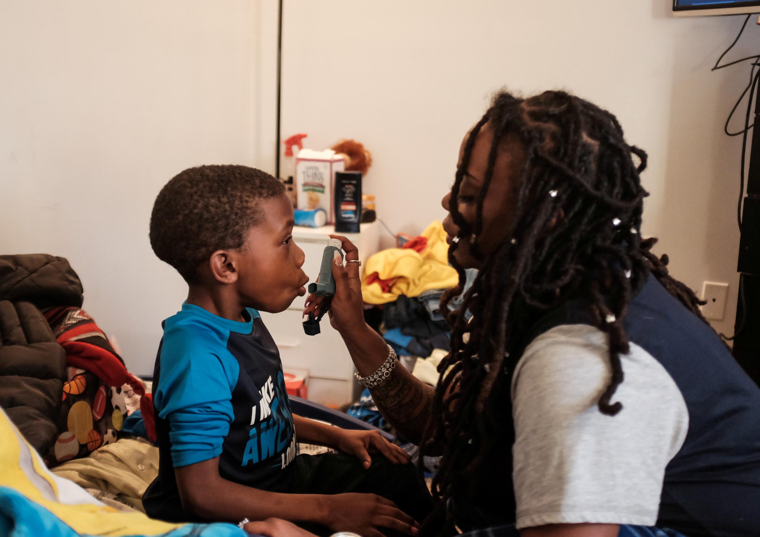 U.S. federal government contractor Yvette Hicks gives her son an asthma treatment before school on the 35th day of the partial federal government shutdown in Washington, U.S. January 25, 2019.