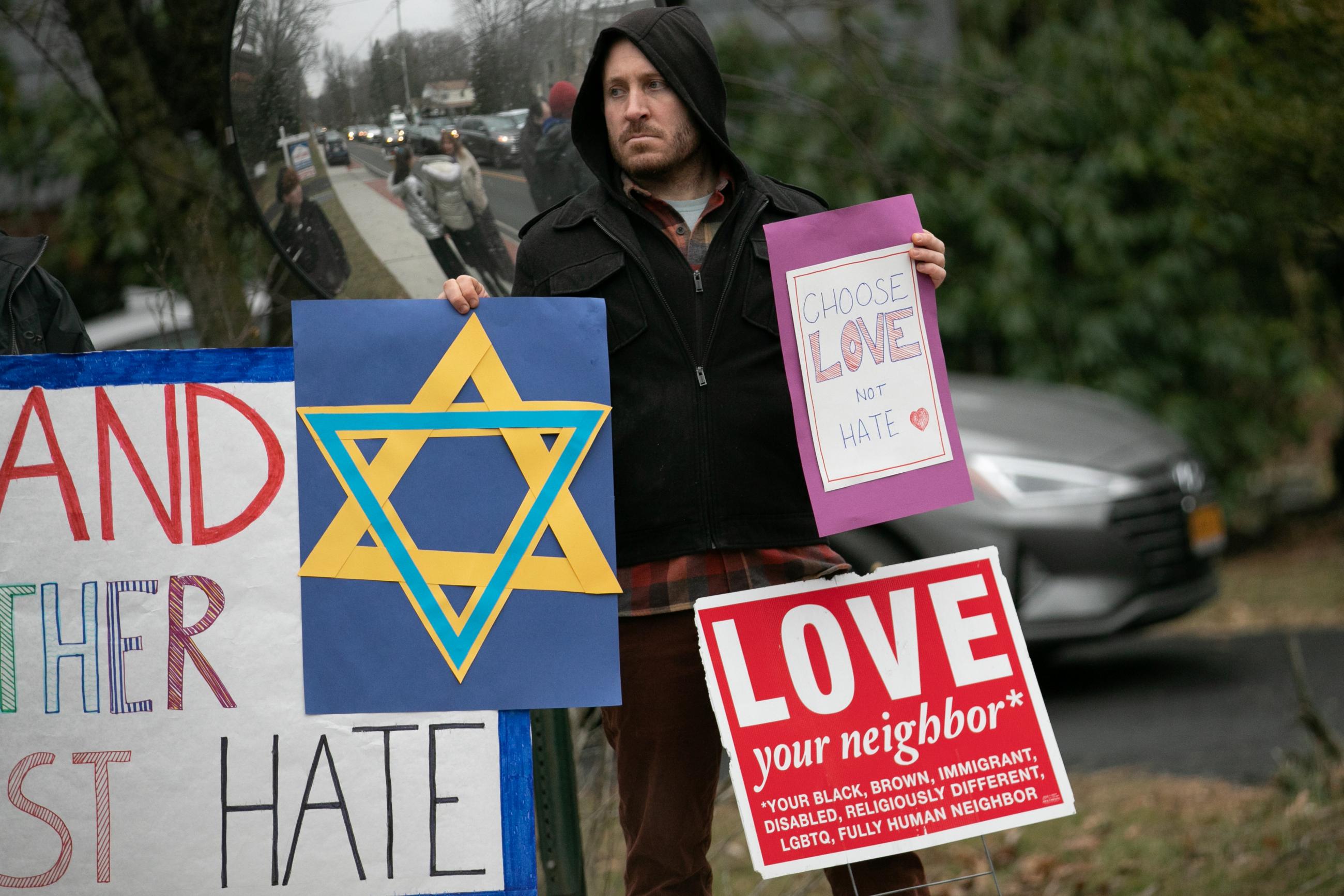 A man holds a sign outside the home of rabbi Chaim Rottenberg in Monsey, New York, U.S., December 29, 2019.