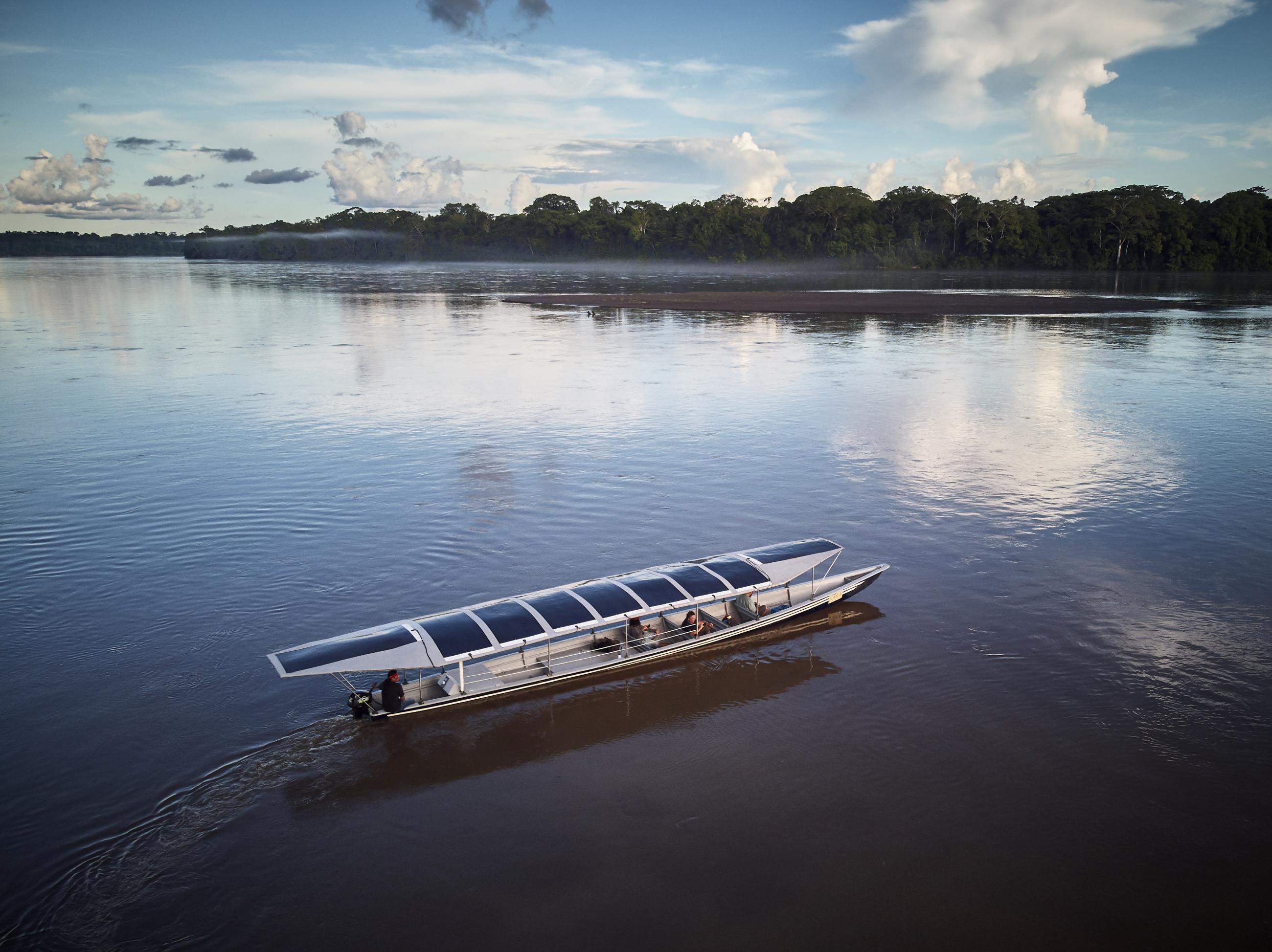 Sunkirum, a solar-powered canoe, sails on the Pastaza River in the Amazon in Ecuador, where the Achuar Indigenous people have lived for thousands of years