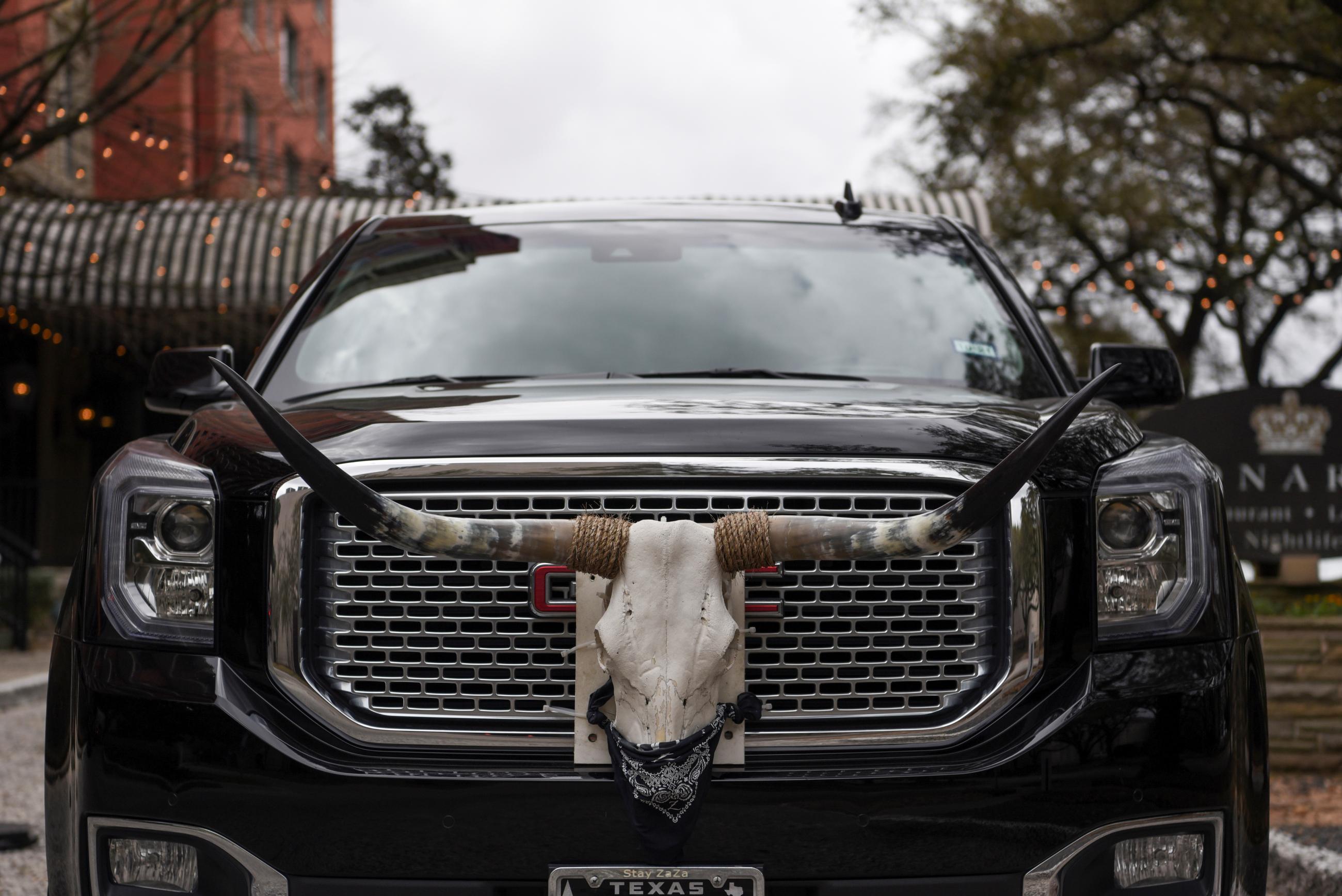 A longhorn skull mounted to a car remained masked as Texas lifted its mask mandate and allowed businesses to reopen at full capacity during the COVID pandemic in Houston, Texas, on March 10, 2021. 