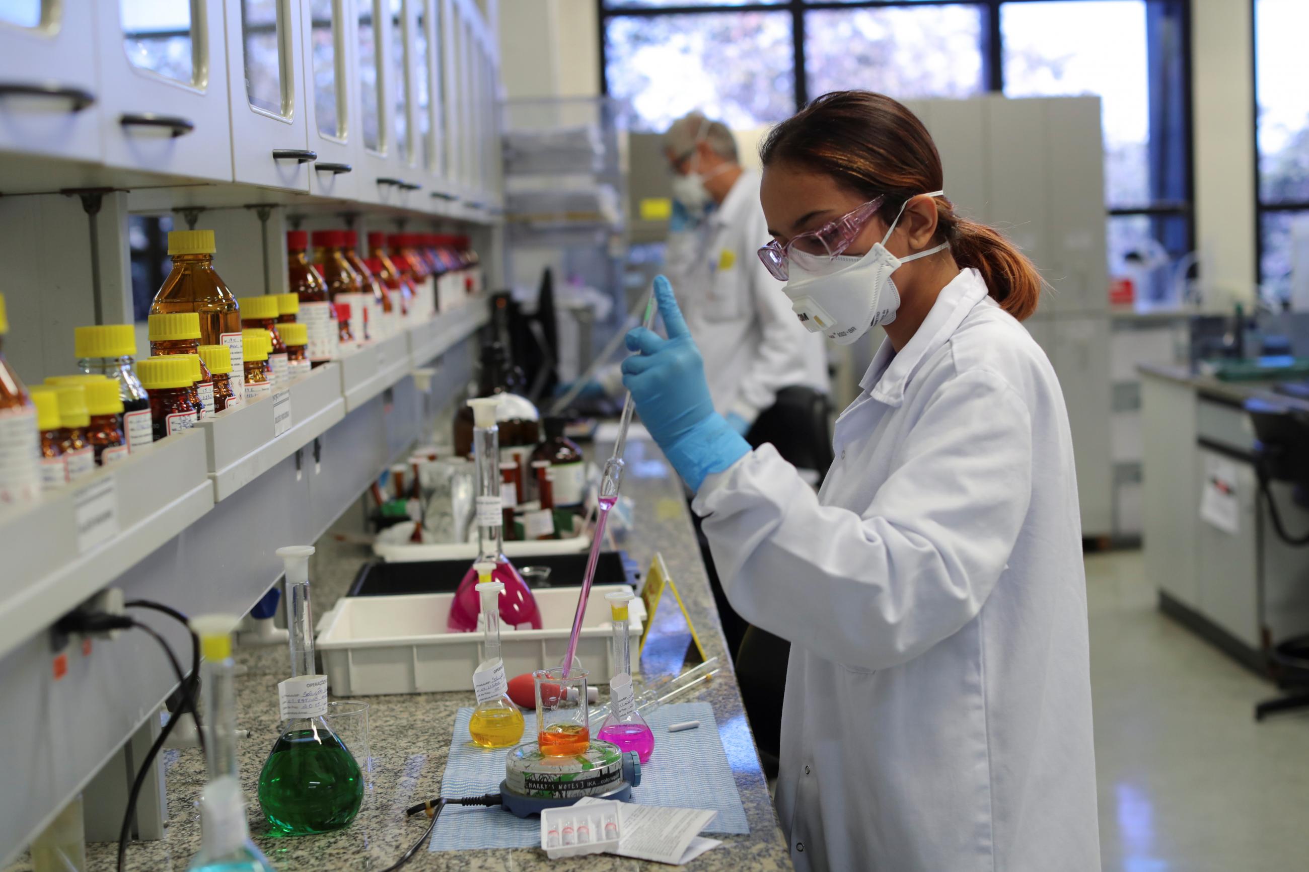 An employee tests the quality of Sputnik V vaccines against COVID-19 in the lab of a Brazilian pharmaceutical company