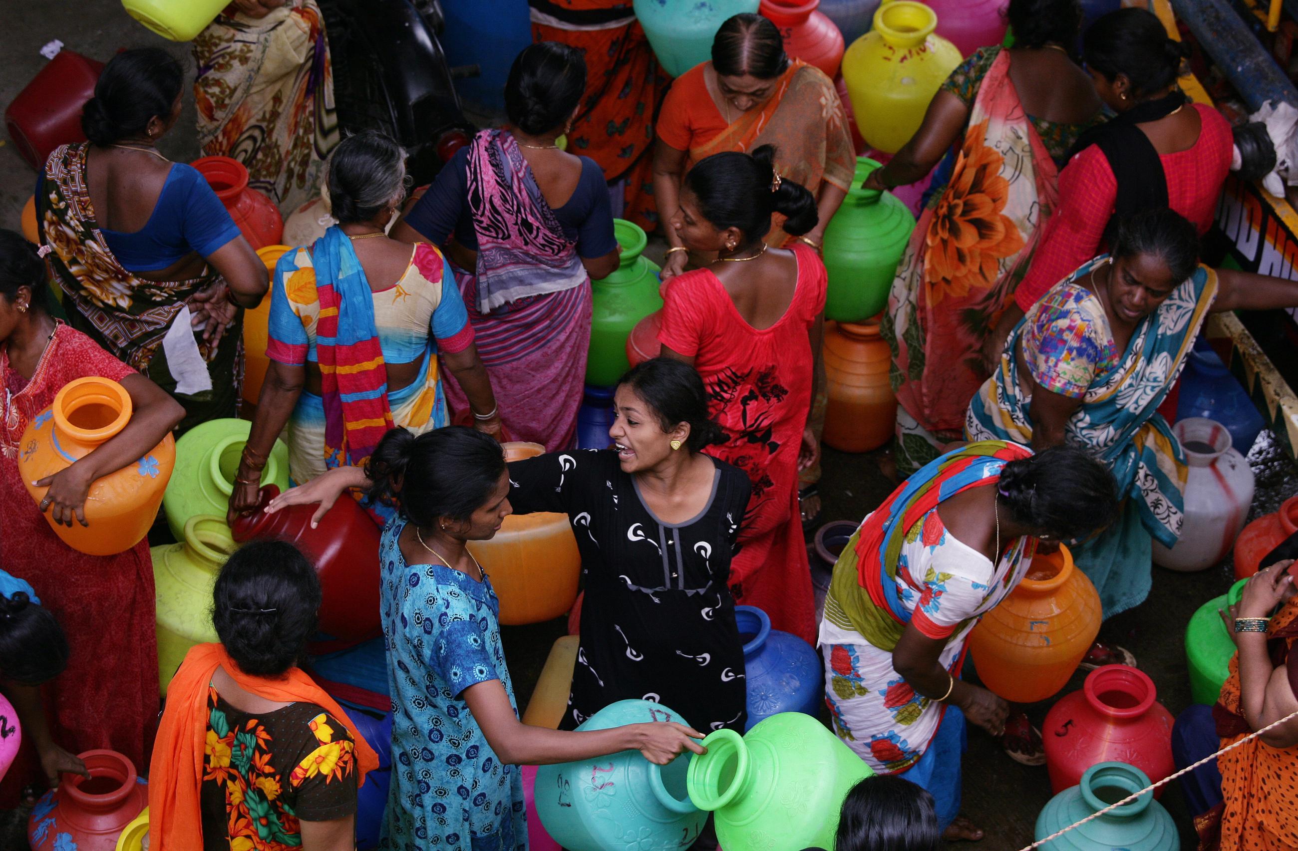 Residents gather to fill empty containers with water from a municipal tanker during a period of extreme drought in Chennai, India, June 25, 2019. 