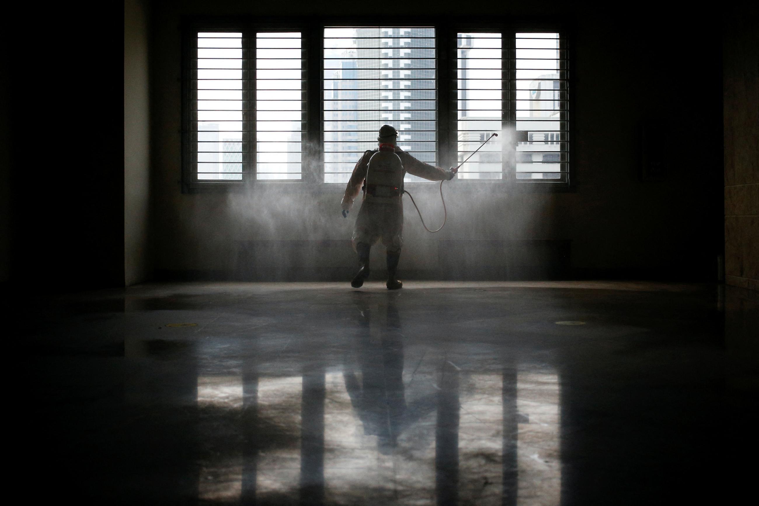 Indonesian Red Cross personnel wearing Personal Protective Equipment (PPE) sprays disinfectant at the National Museum that is closed as the Omicron coronavirus variant spreads, in Jakarta, Indonesia, February 4, 2022.