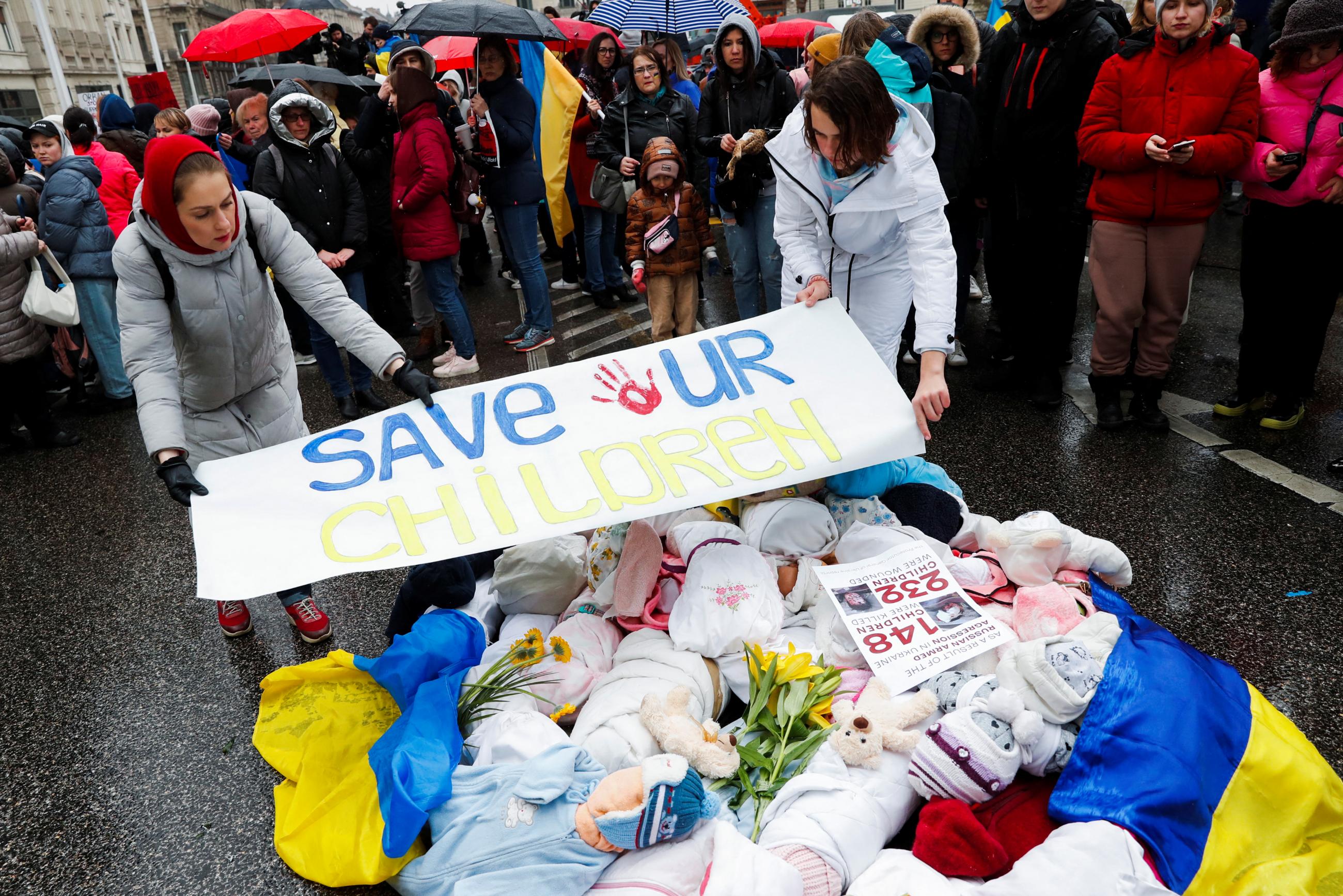Ukrainian women who fled Russia's invasion of Ukraine carry dummy babies symbolizing children who were killed in the conflict and a sign that reads "Save Our Children", during a Mothers March in Budapest, Hungary, April 2, 2022