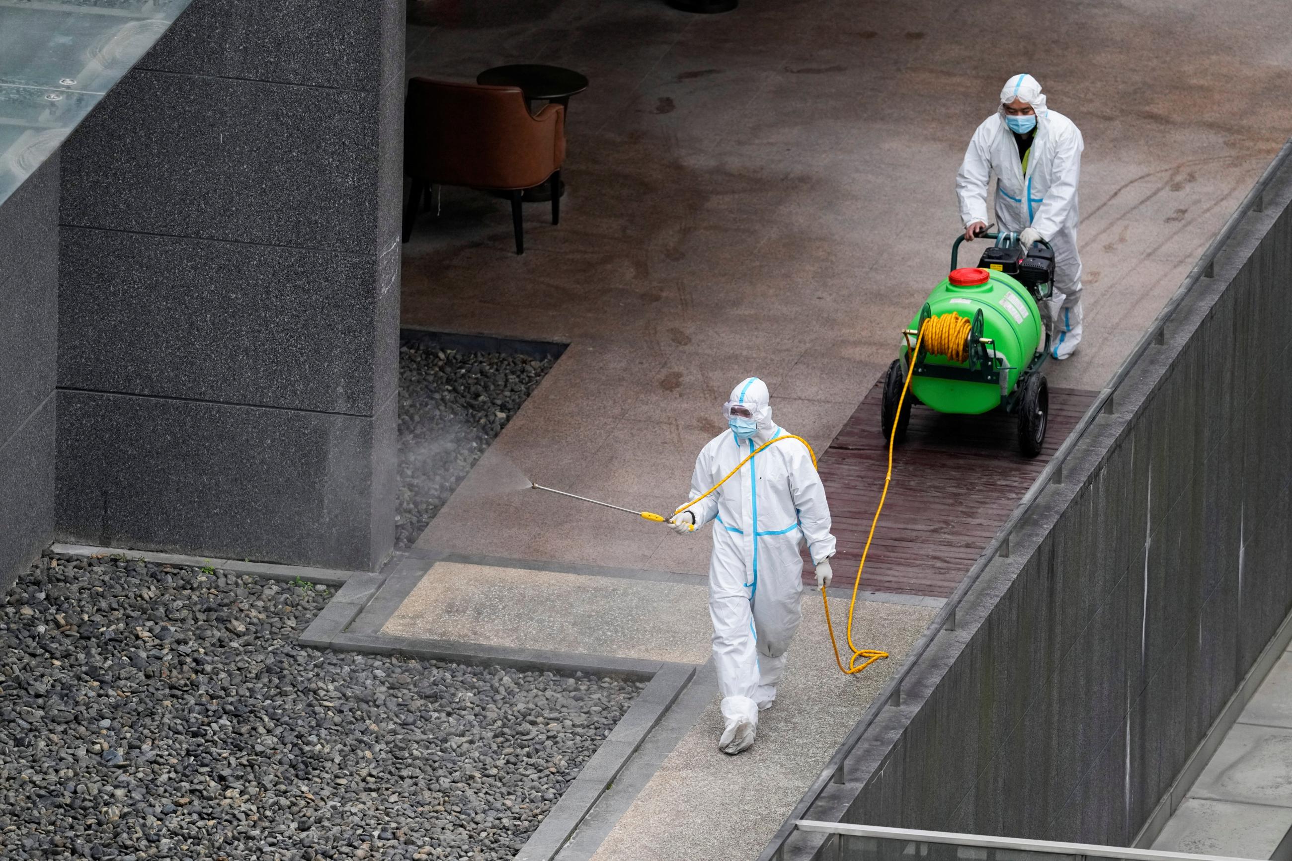Workers in protective suit spray disinfectant at a community, during the lockdown to curb the spread of the coronavirus disease (COVID-19) in Shanghai, China, April 5, 2022.