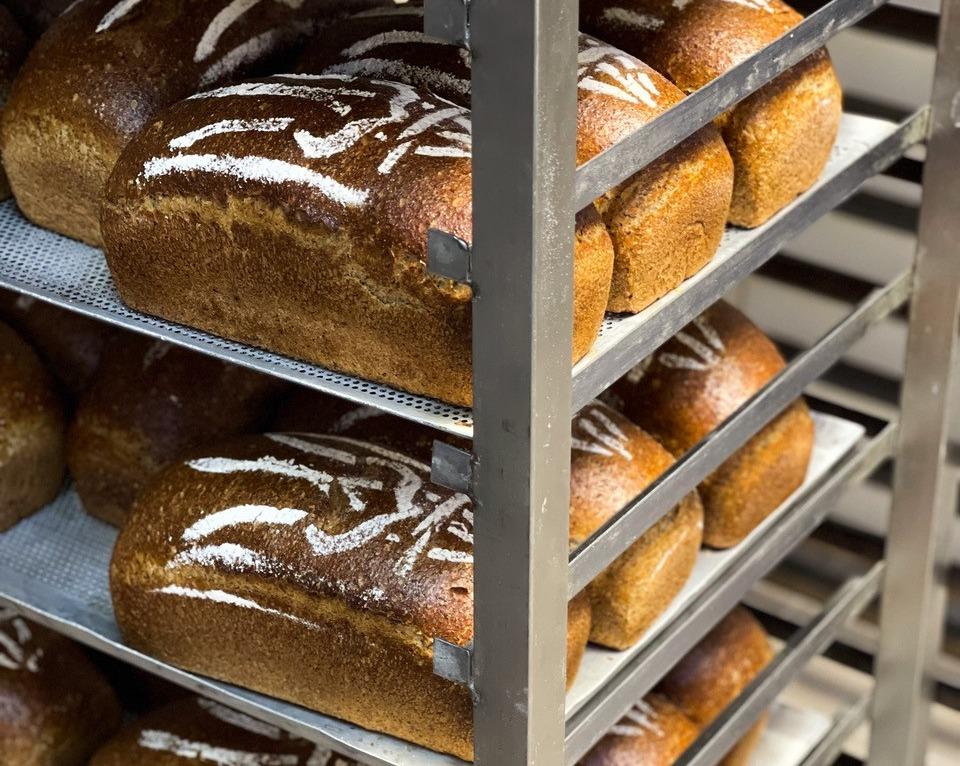 Loaves of bread decorated with the Ukrainian trident cool on racks at Bakehouse in Kyiv, Ukraine