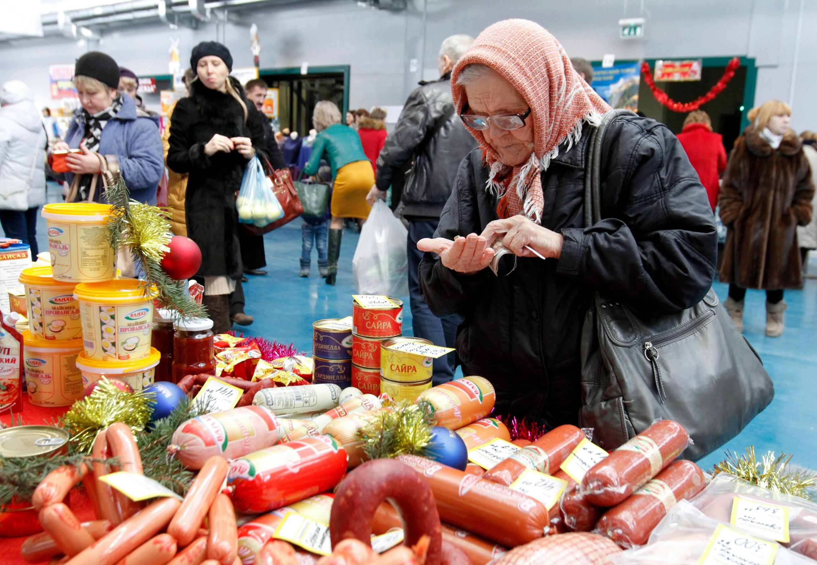An elderly woman counts money at a food fair in the village of Ulyanovka, south-east of Stavropol, Russia, in this December 22, 2015