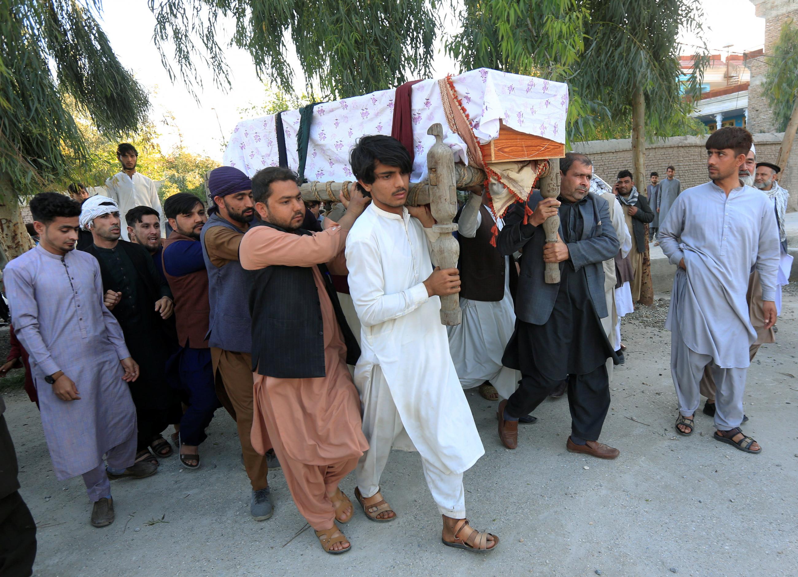 Men carry the coffin of one of three female polio vaccination health workers who were shot and killed by unknown gunmen at two separate locations, during a burial ceremony in Jalalabad, Afghanistan March 30, 2021. 