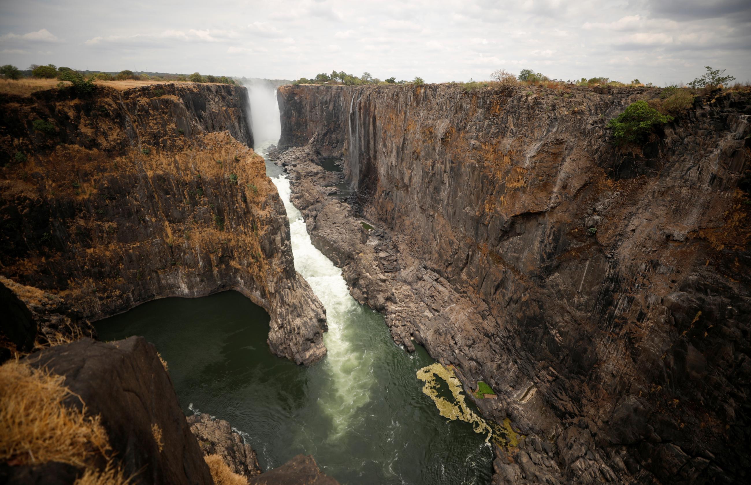 A parched gorge in Victoria Falls, Zimbabwe is pictured against a gray sky 