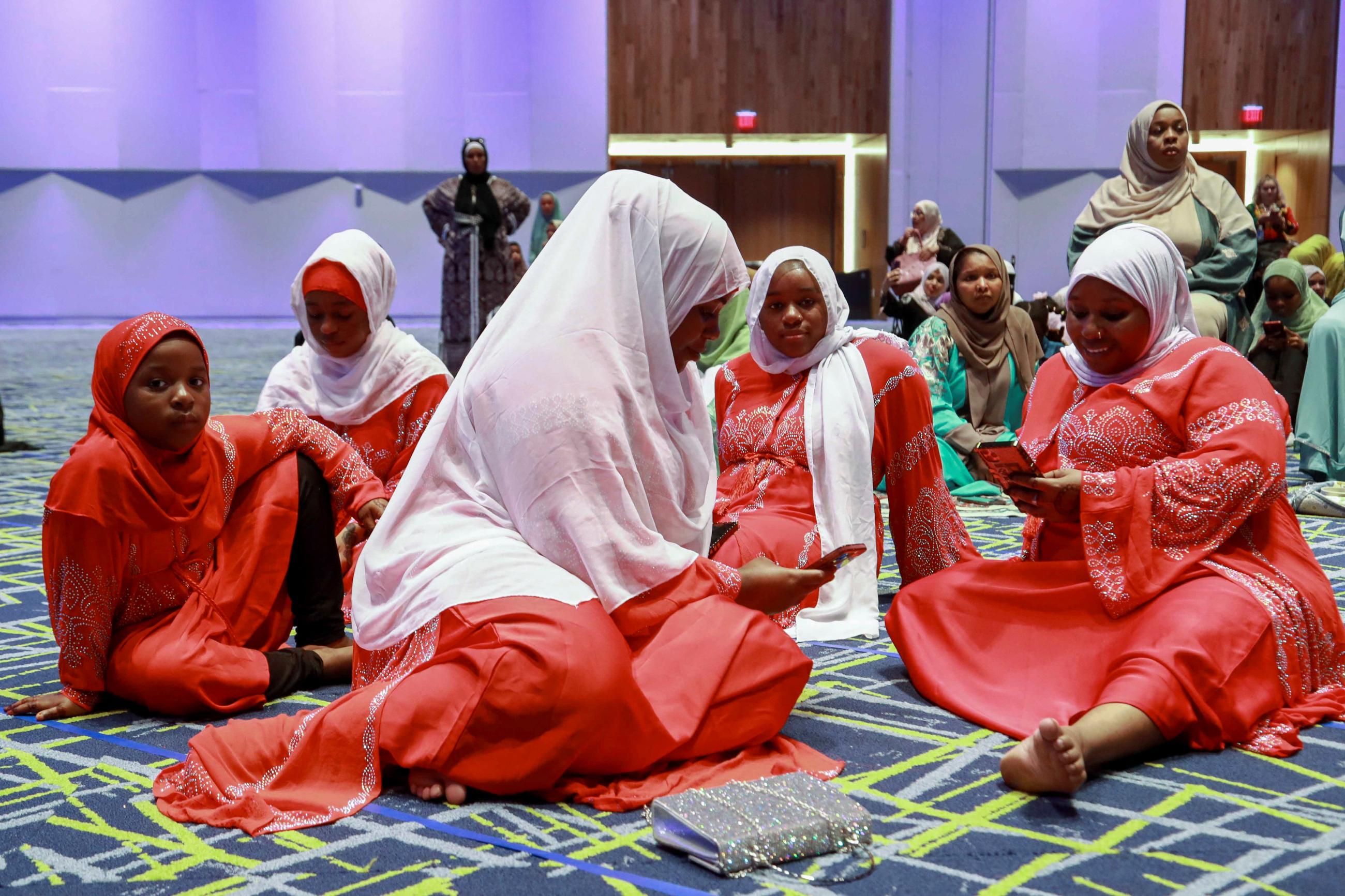 The Alis, an immigrant family from Kenya, sit together on the floor, gathering with the Muslim community at Kentucky International Convention Center to celebrate the Eid al-Adha festival, in Louisville, Kentucky, on July 9, 2022. 