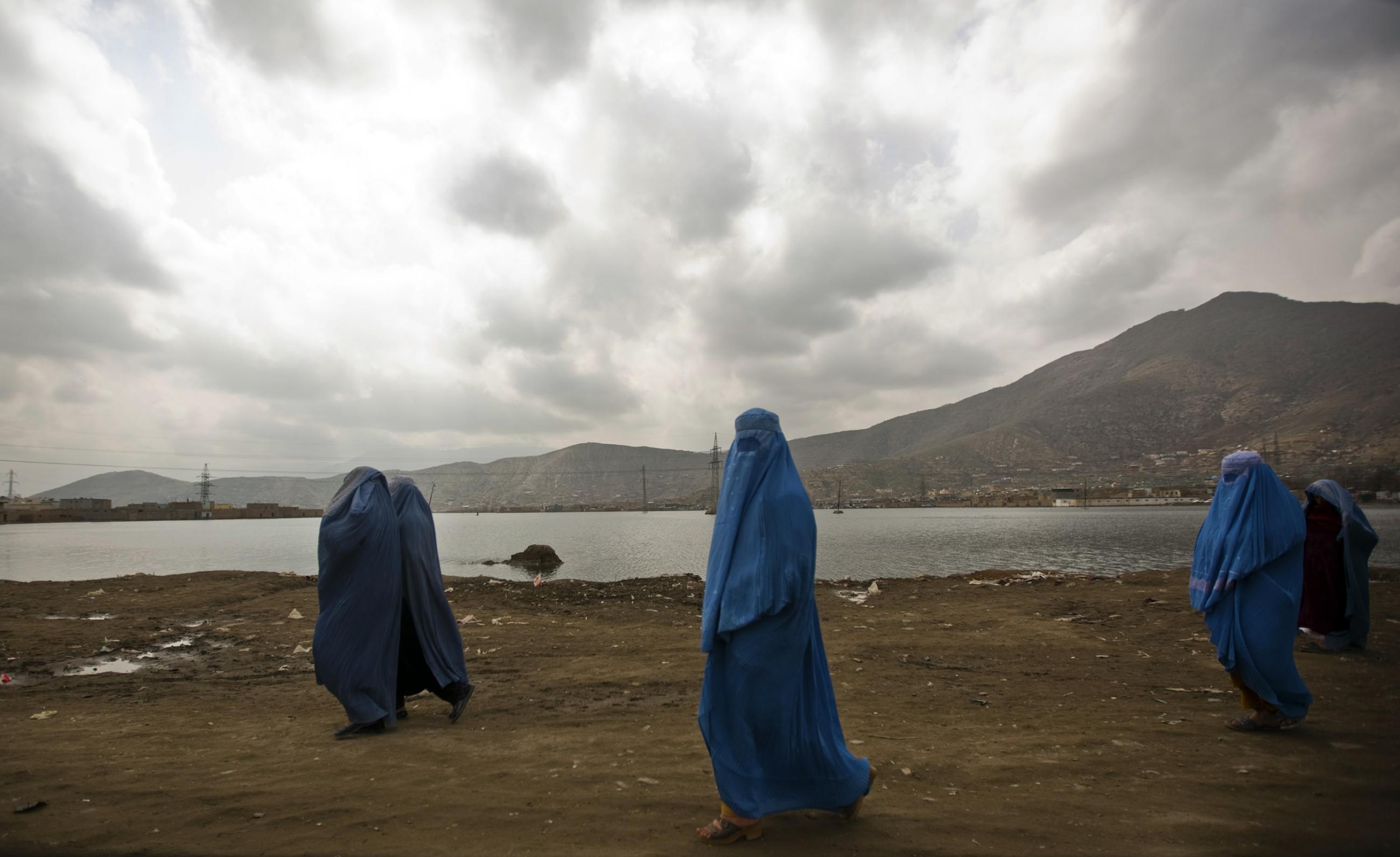 Afghan women clad in burqa walk along a road in Kabul, Afghanistan, on March 28, 2011.