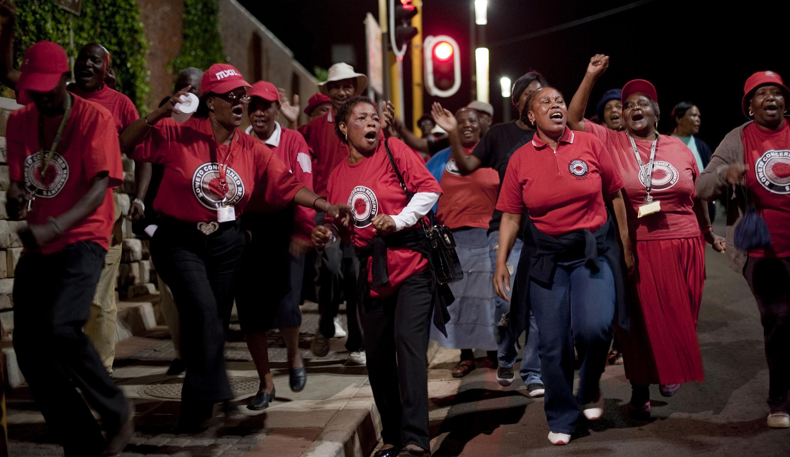 Activists and supporters of the Right 2 Know campaign chant slogans as they hold a night vigil outside the Constitutional Court in Johannesburg September 19, 2011.