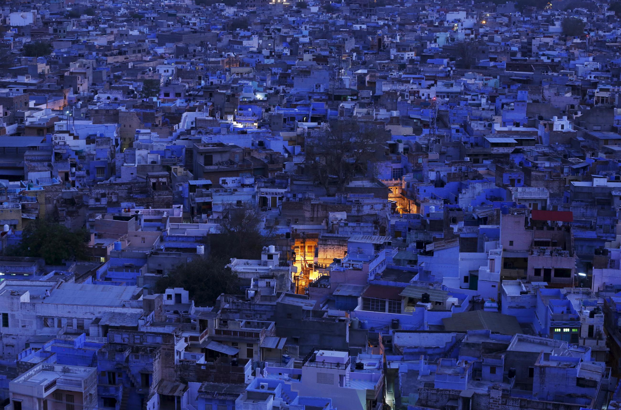 An aerial view of a residential area is pictured during dusk at Jodhpur, India on April 5, 2015. All the buildings are painted blue to help keep buildings cool. Two places in the city are lit by bright yellow lights.