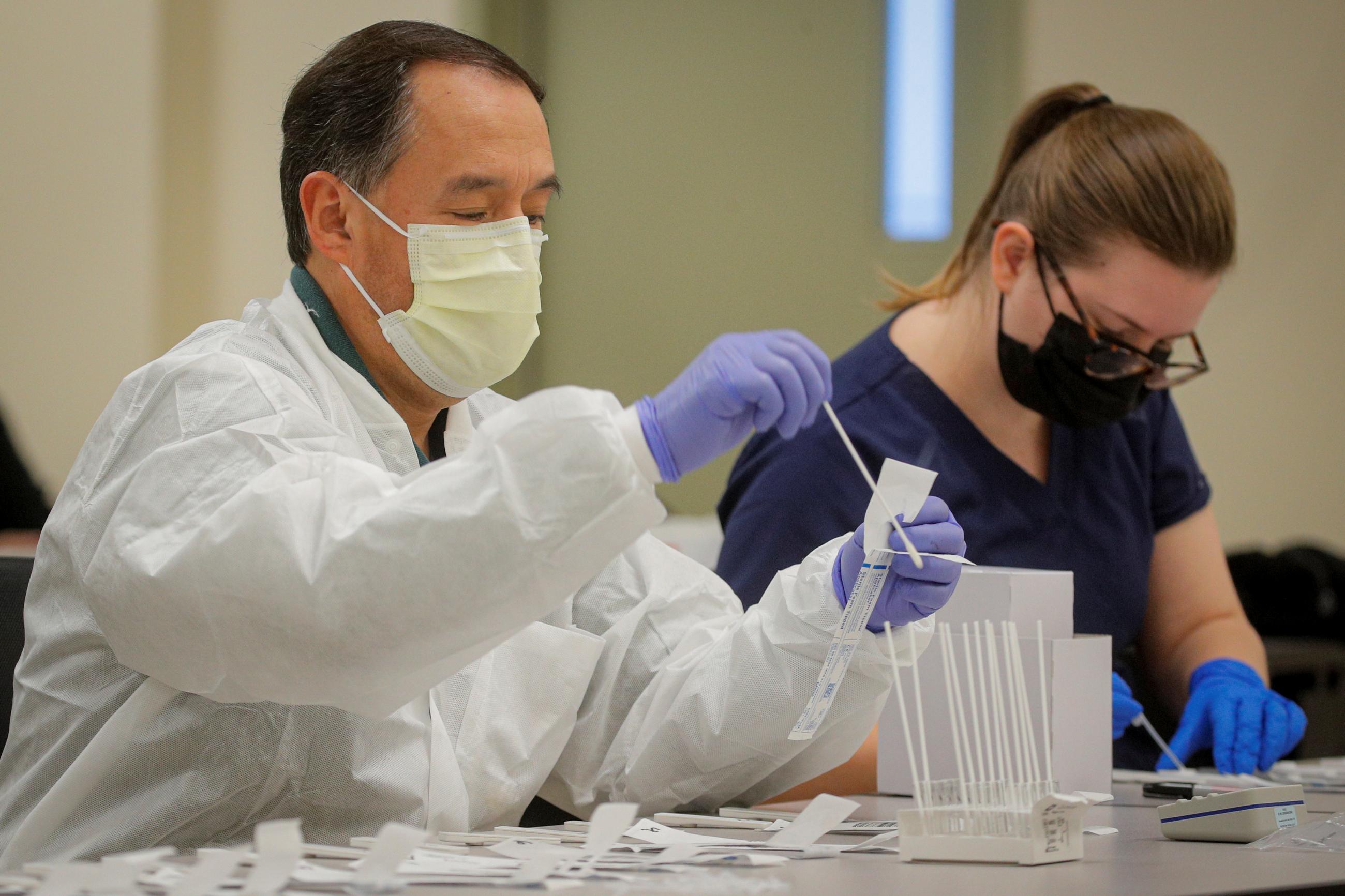 A health care worker prepares coronavirus tests in a lab at a COVID drive-thru testing center at Bergen Community College, as the global outbreak of the coronavirus disease (COVID-19) continues, in Paramus, New Jersey, U.S., December 3, 2020.