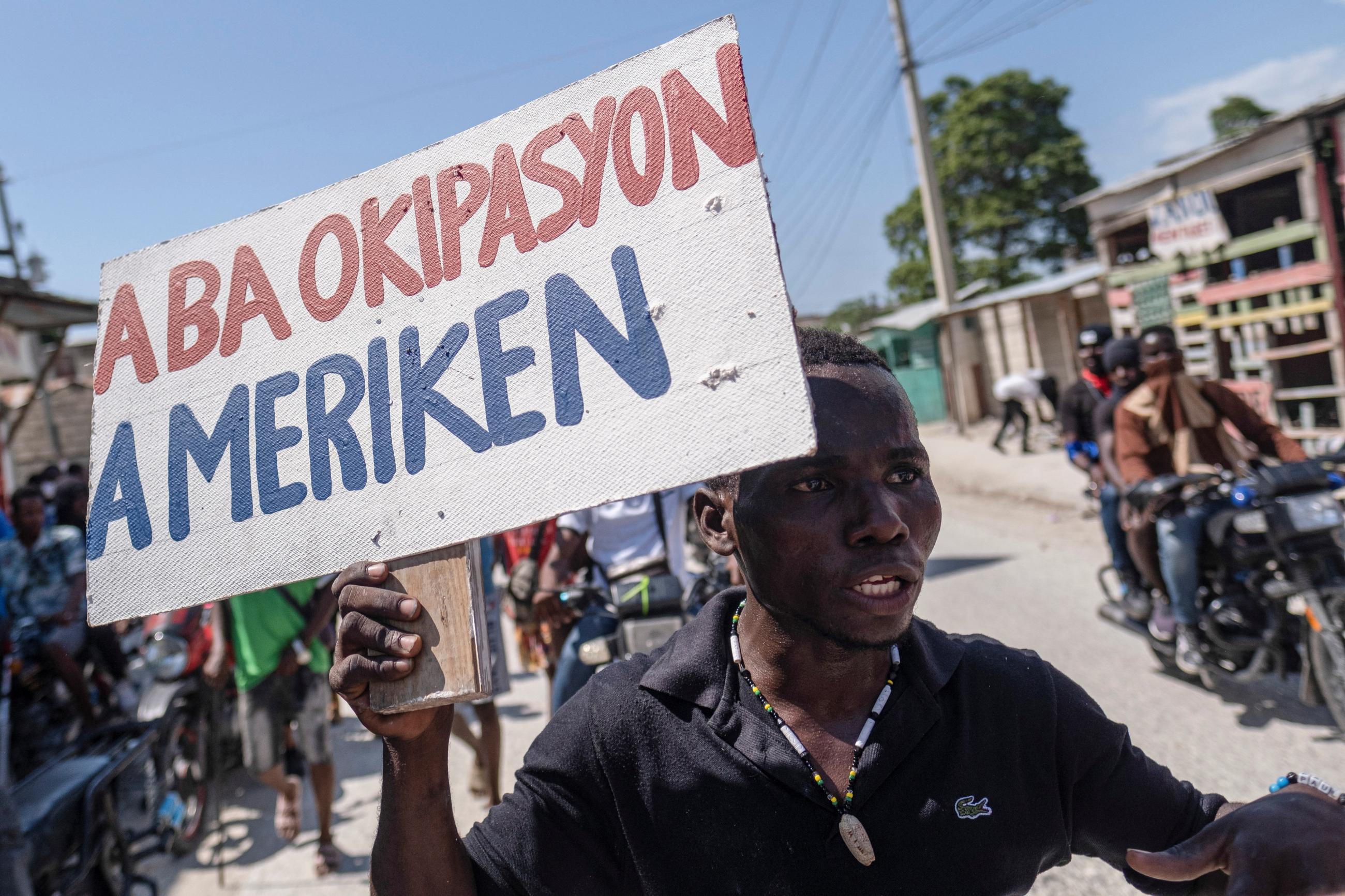 A man holds a placard that reads in Creole “Down with the American Occupation” during a protest in n Port-au-Prince, Haiti, on October 17, 2022.  