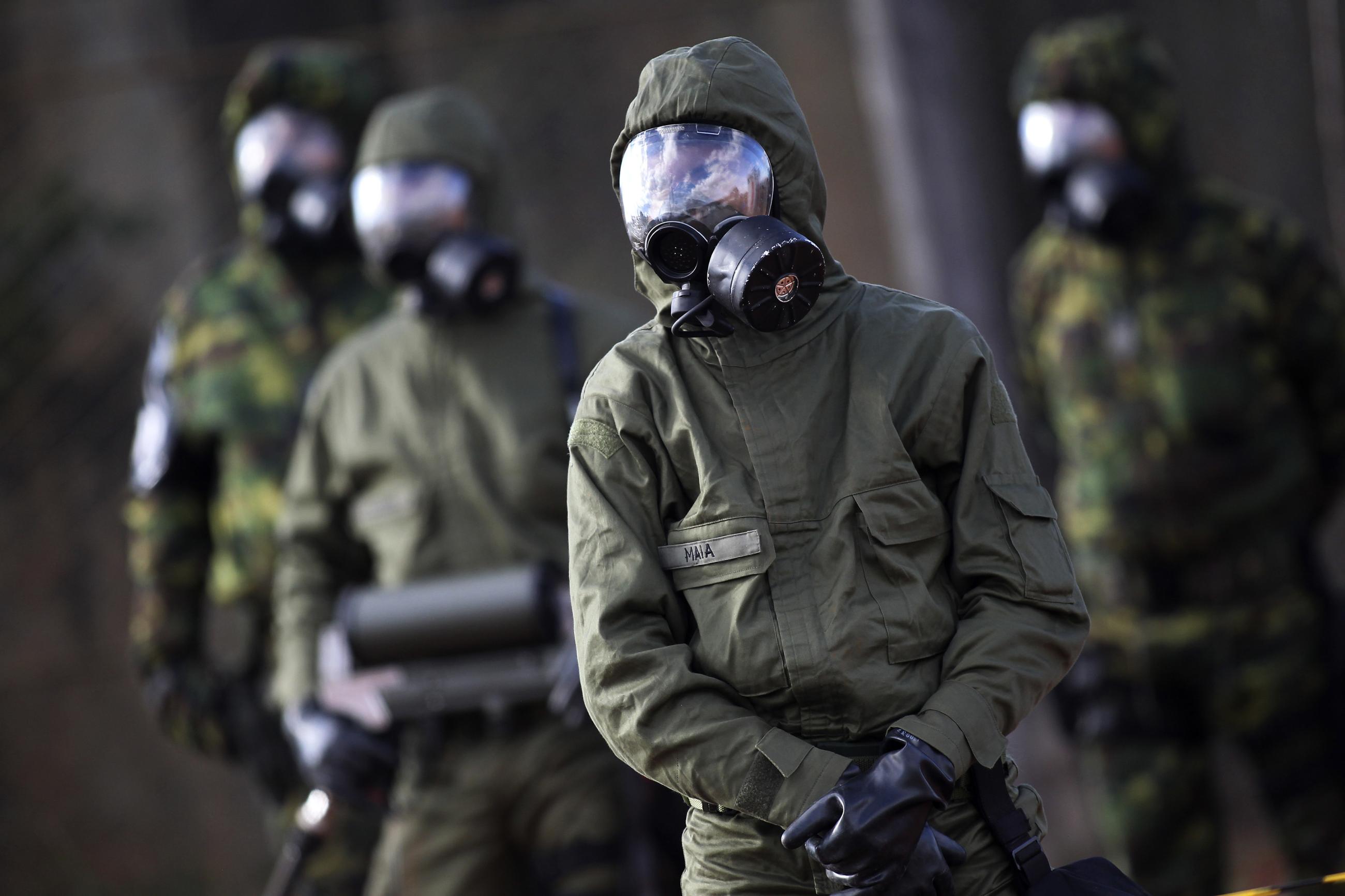 Brazilian army soldiers wear gas masks and chemical suits participate in an anti-terror simulation against chemical, biological, and radiological weapons, near Arena BRB Mané Garrincha, in Brasília, Brazil.