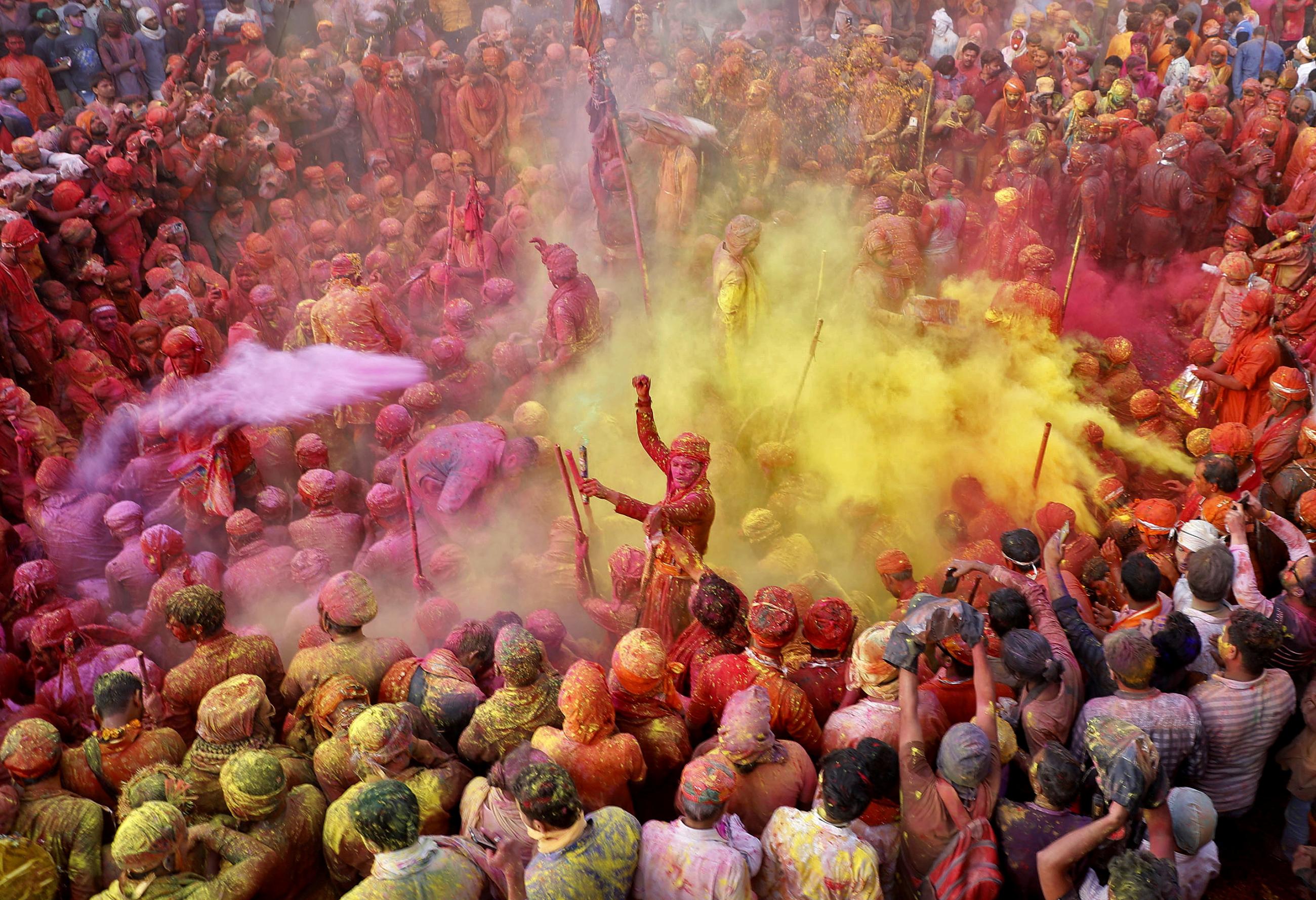 Men throw colored powder at each other during Lathmar Holi celebrations in the town of Nandgaon, in the northern state of Uttar Pradesh, India, March 24, 2021.