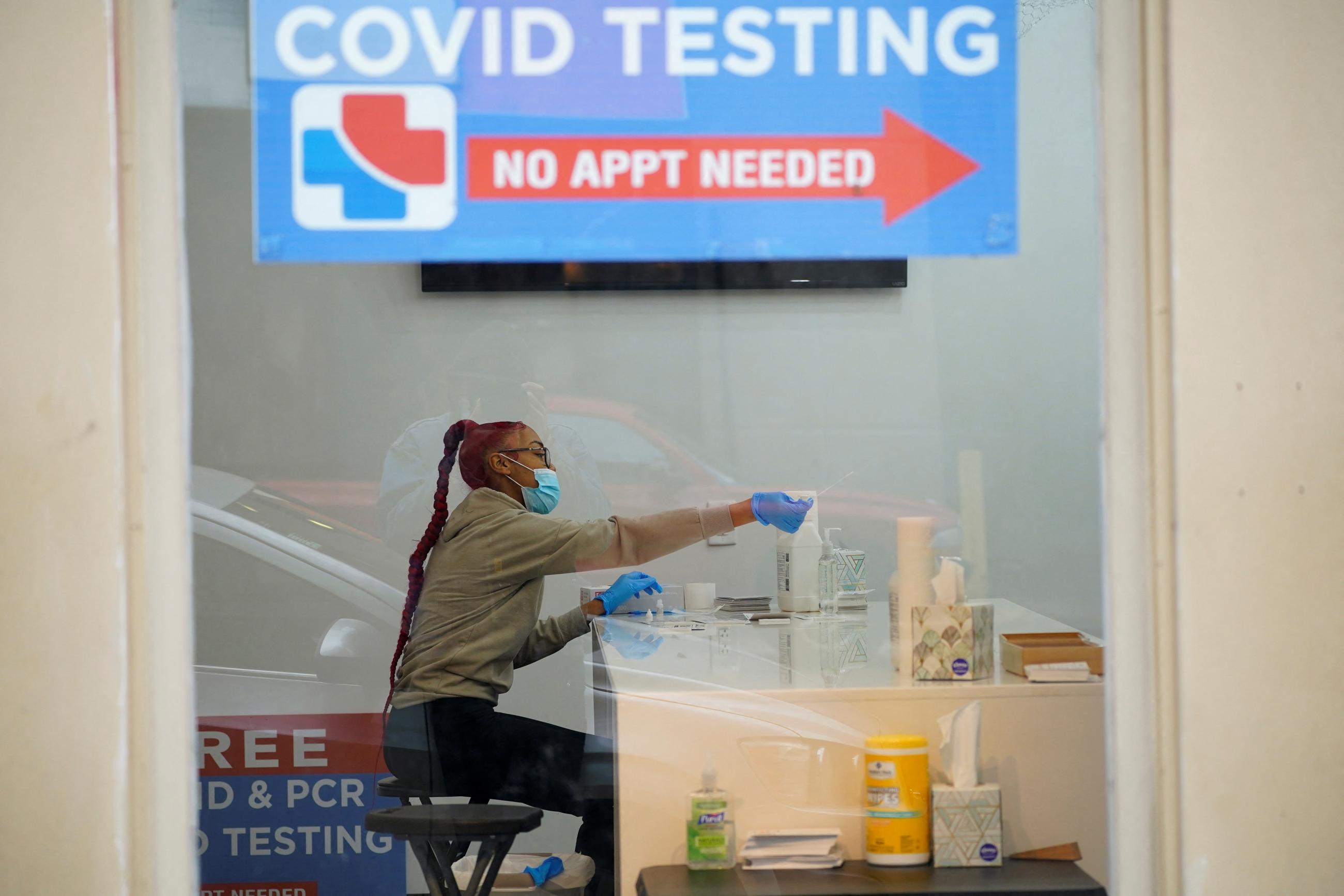 A healthcare worker reaches out to give a person a nasal swab to test for the coronavirus disease (COVID-19), as the Omicron variant continues to spread in Indianapolis, Indiana, U.S., December 29, 2021.