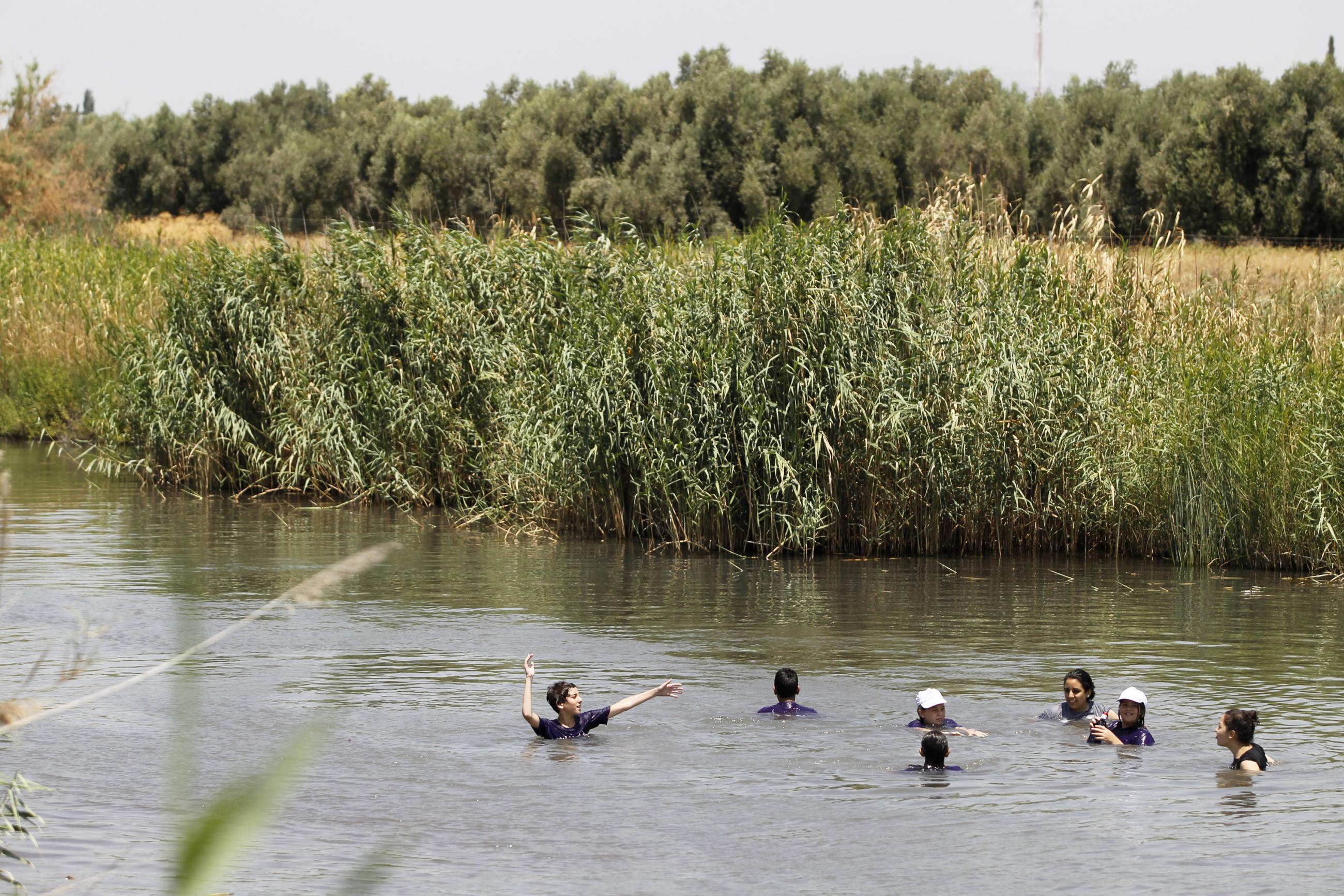 Youths bathe in a stream at the Valley of Springs near the Jordan River July 16, 2012. The Biblical river, which has inspired countless spirituals and folk songs, is just a narrow stream in many parts - polluted and stagnant. But that's about to change. Thanks to desalination and wastewater recycling, there is more fresh water to go around and the Jordan will slowly be returned to its former glory. 