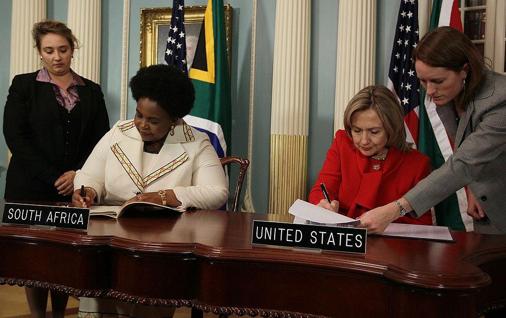 Secretary of State Hillary Clinton (2nd R) and South African Foreign Minister Maite Nkoana-Mashabane (2nd L) sign documents during a news conference at the State Department on December 14, 2010 in Washington, DC