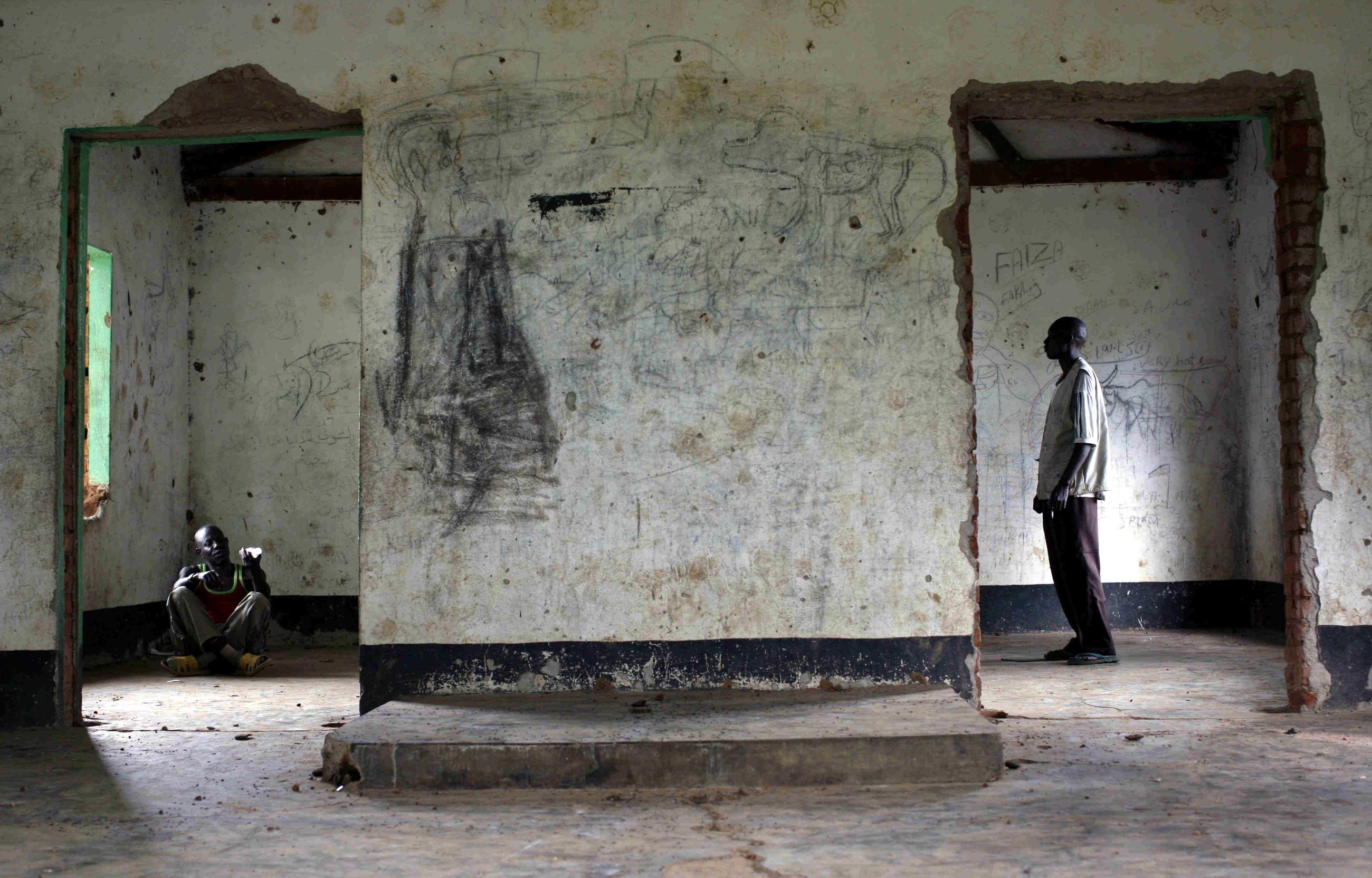 Apollo Longa-Kenyi (R), a leprosy counselling and care worker, counsels a patient Saviour Gabu in an abandoned village building in Mogiri, southern Sudan July 7, 2007.