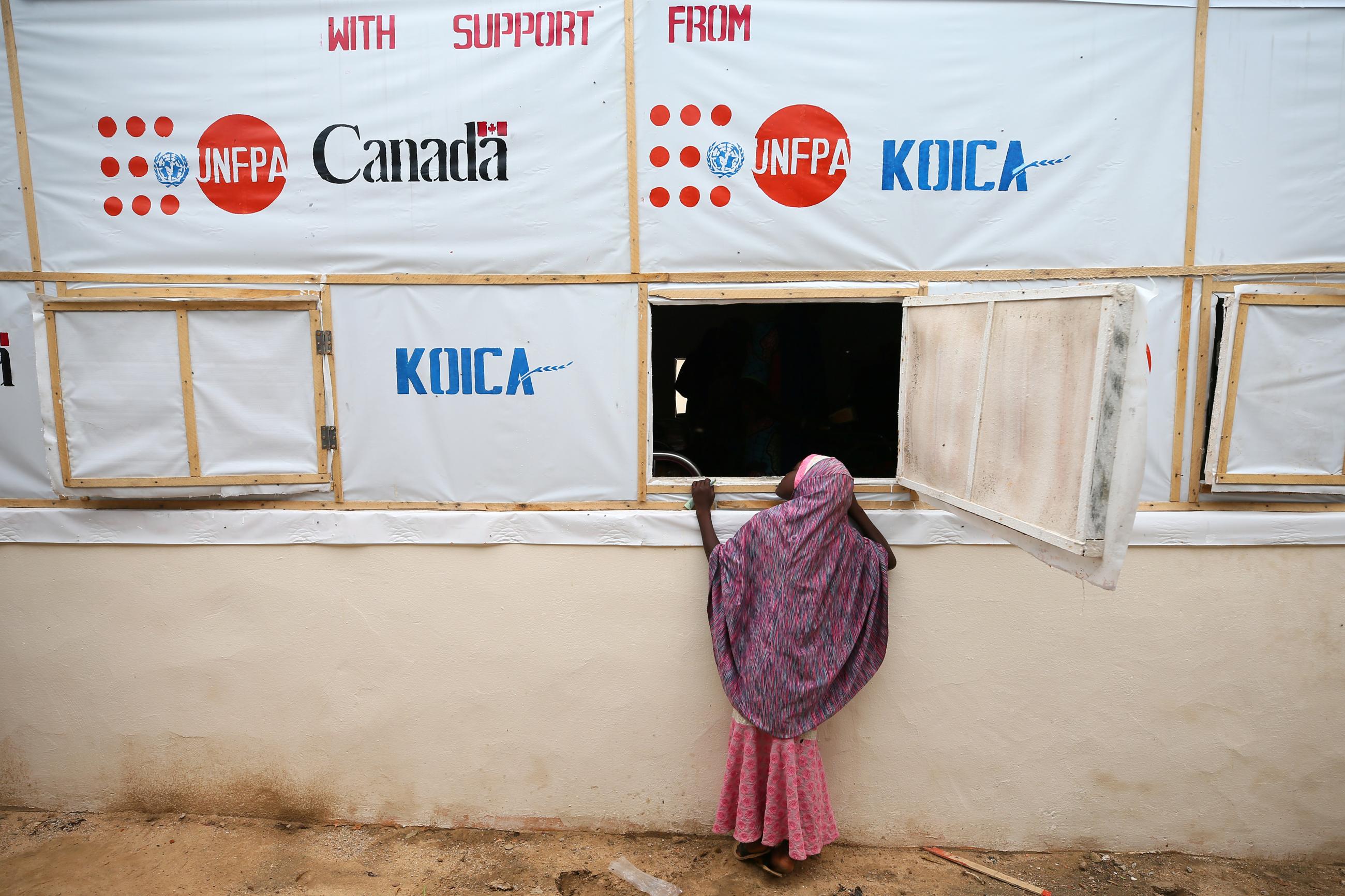 A girl looks through a window of a recovery ward at an obstetric fistula repair center in Maiduguri, Nigeria, on August 1, 2018.