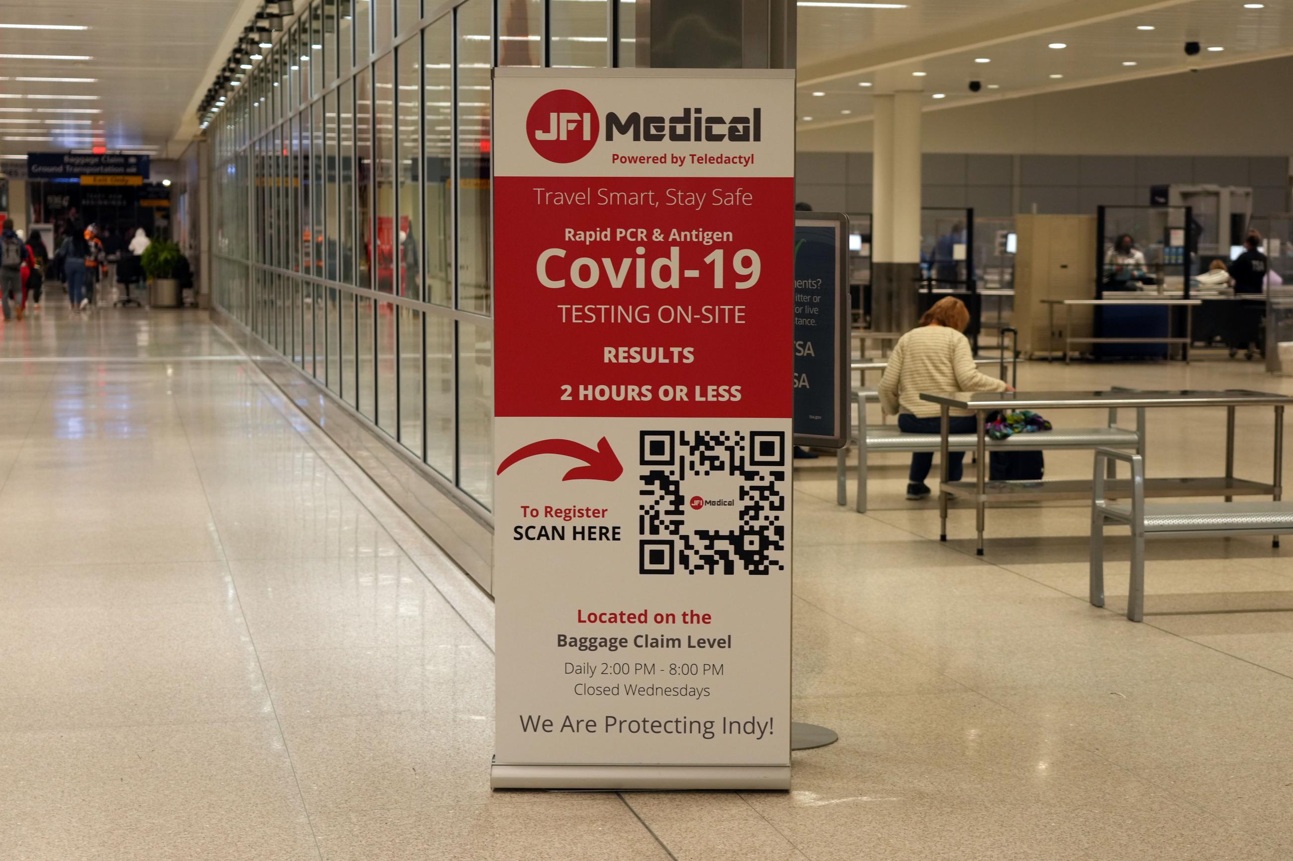 A COVID-19 rapid PCR and Antigen testing sign is seen at the Indianapolis International Airport amid the surge of the omicron and delta variants, on January 10, 2022.