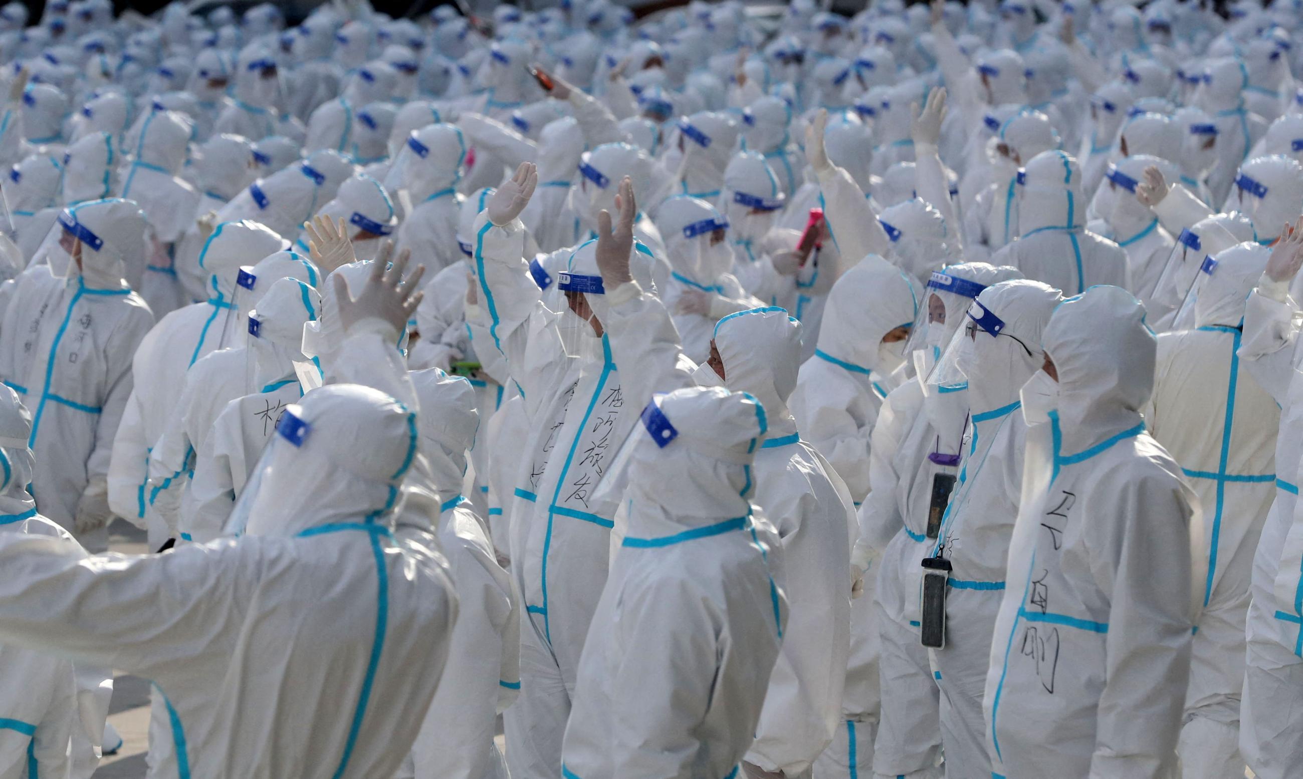 Medical workers in protective suits wave at Changchun residents during a farewell ceremony before returning to Meihekou, where they were dispatched from to help curb the coronavirus disease (COVID-19) outbreak in Changchun, Jilin Province, China, April 12, 2022