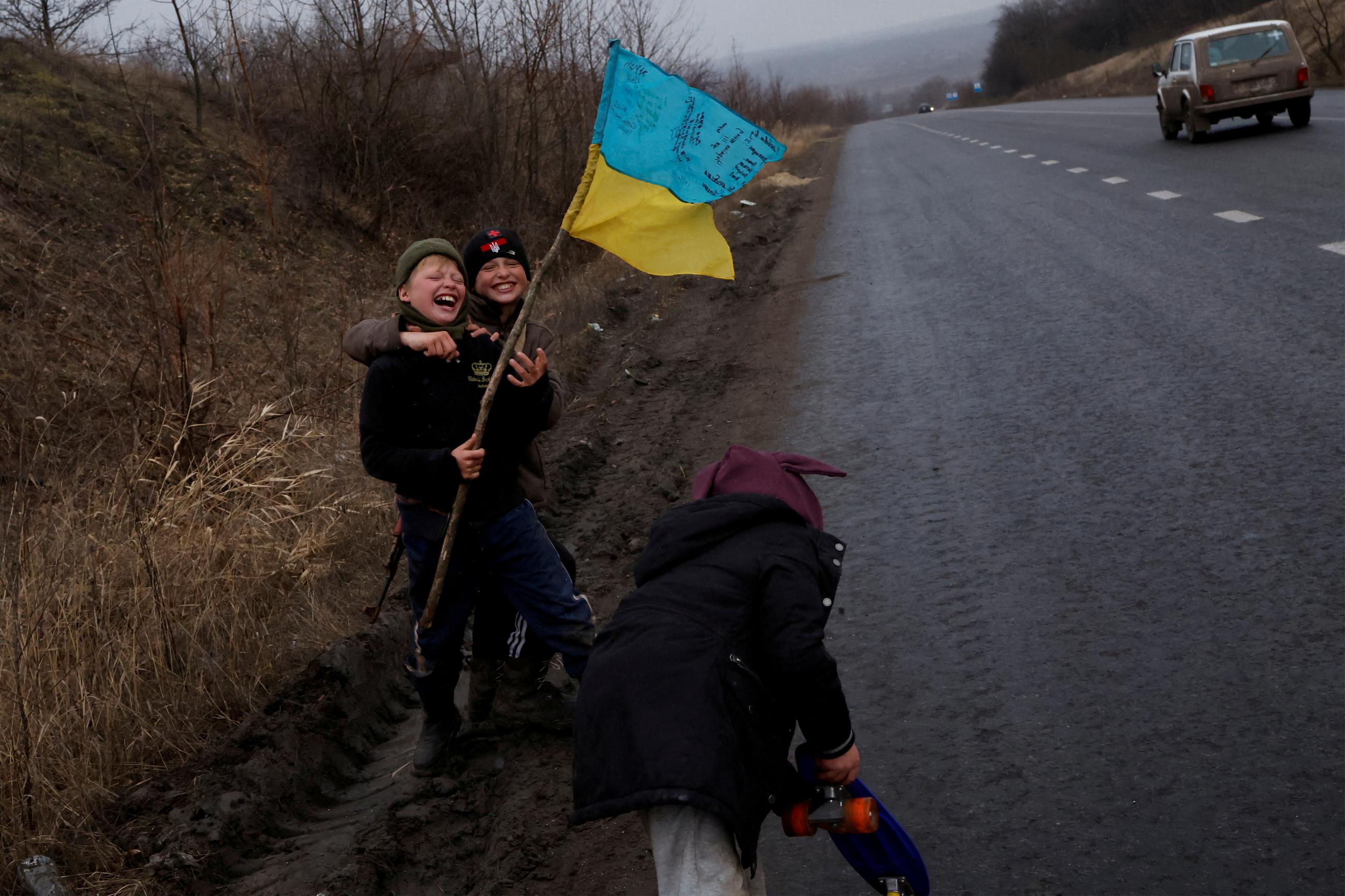 Children play along the side of the road in Bakhmut, Ukraine, on January 5, 2023, as Russia's attack on Ukraine continues.