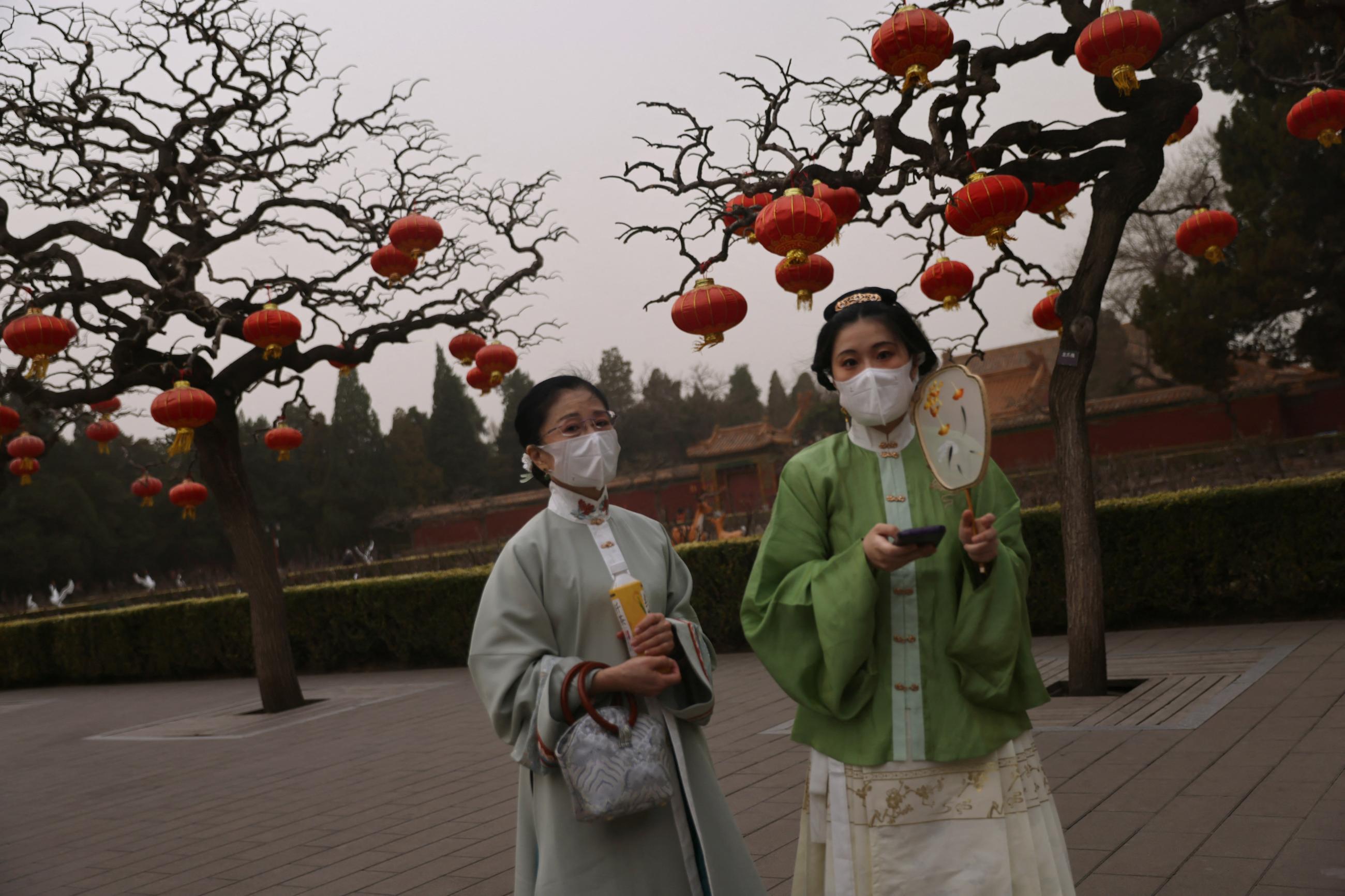 Women dressed in traditional hanfu clothing walk at Jingshan Park as the city is shrouded in smog amid a sandstorm in Beijing, China, on March 10, 2023. REUTERS/Tingshu Wang