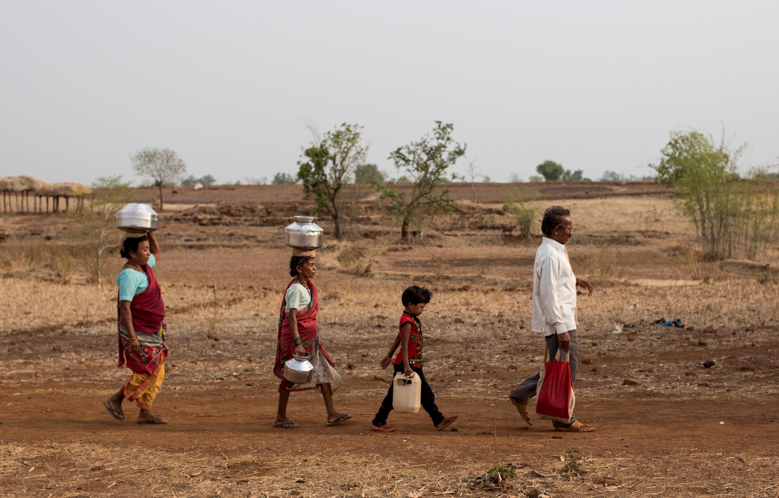 DOCUMENT DATE:  June 04, 2015  Bhaagi (left) and Sakhri (second from left), wives of Sakharam Bhagat (right) walk to fetch water from a well outside Denganmal village, Maharashtra, India, on April 20, 2015