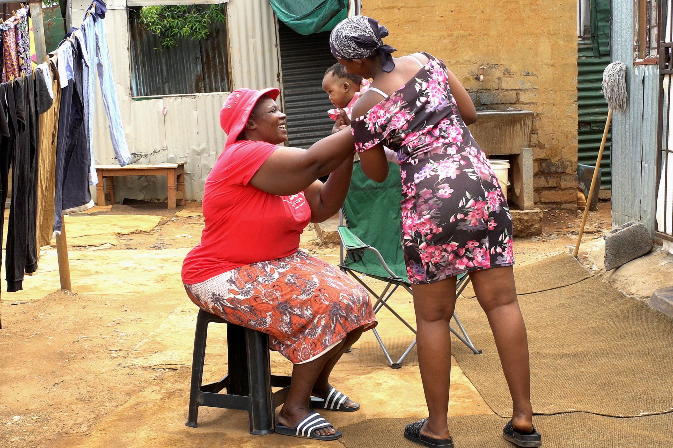 Rebecca Phaka takes her grandchild from her daughter Serena Phaka (15) who struggles to come to terms with the challenges of being a teen mother in Tembisa, South Africa, on August 21, 2022.