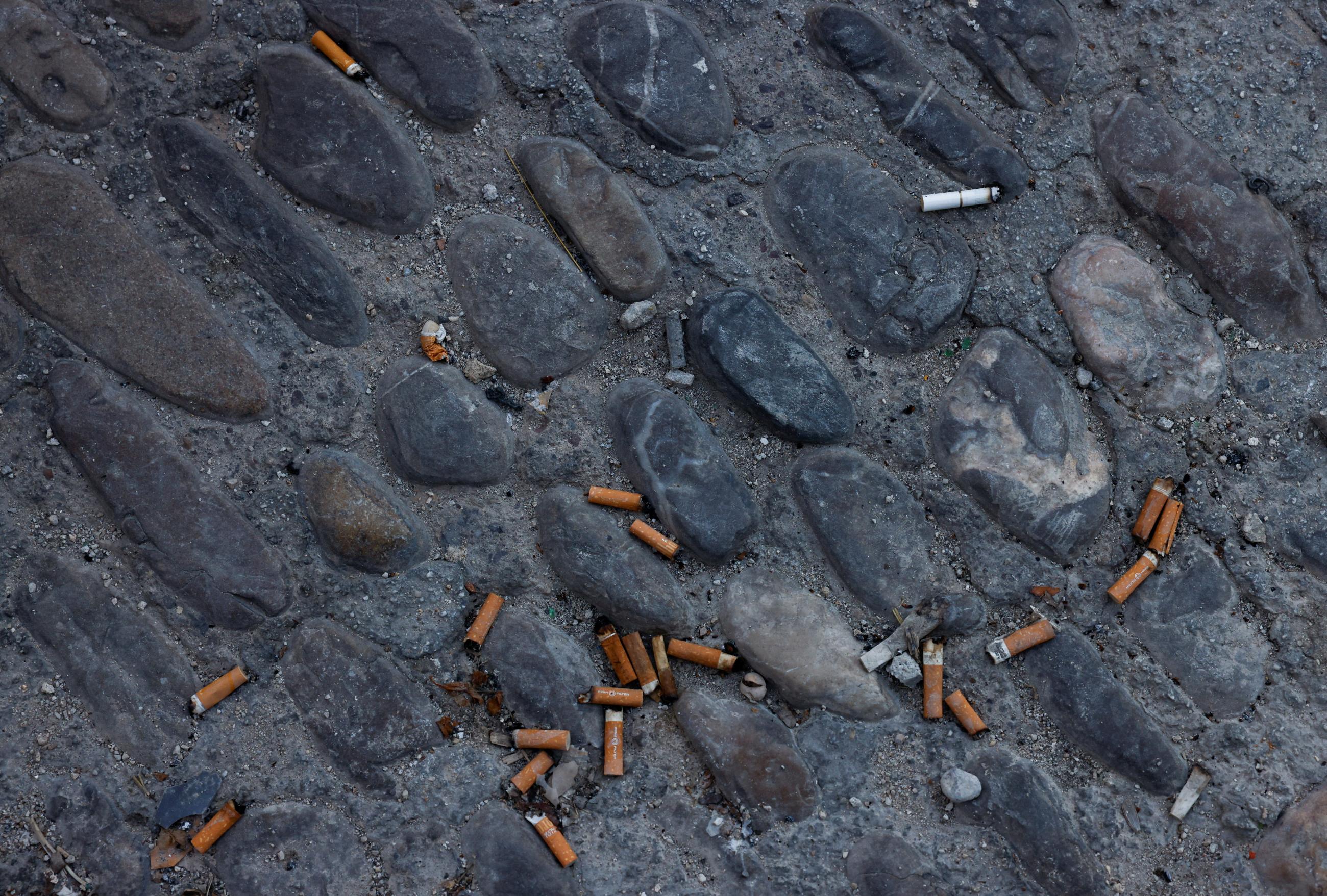 Cigarette butts are left on the floor outside a pub in Ronda, Spain, October 13, 2022. 