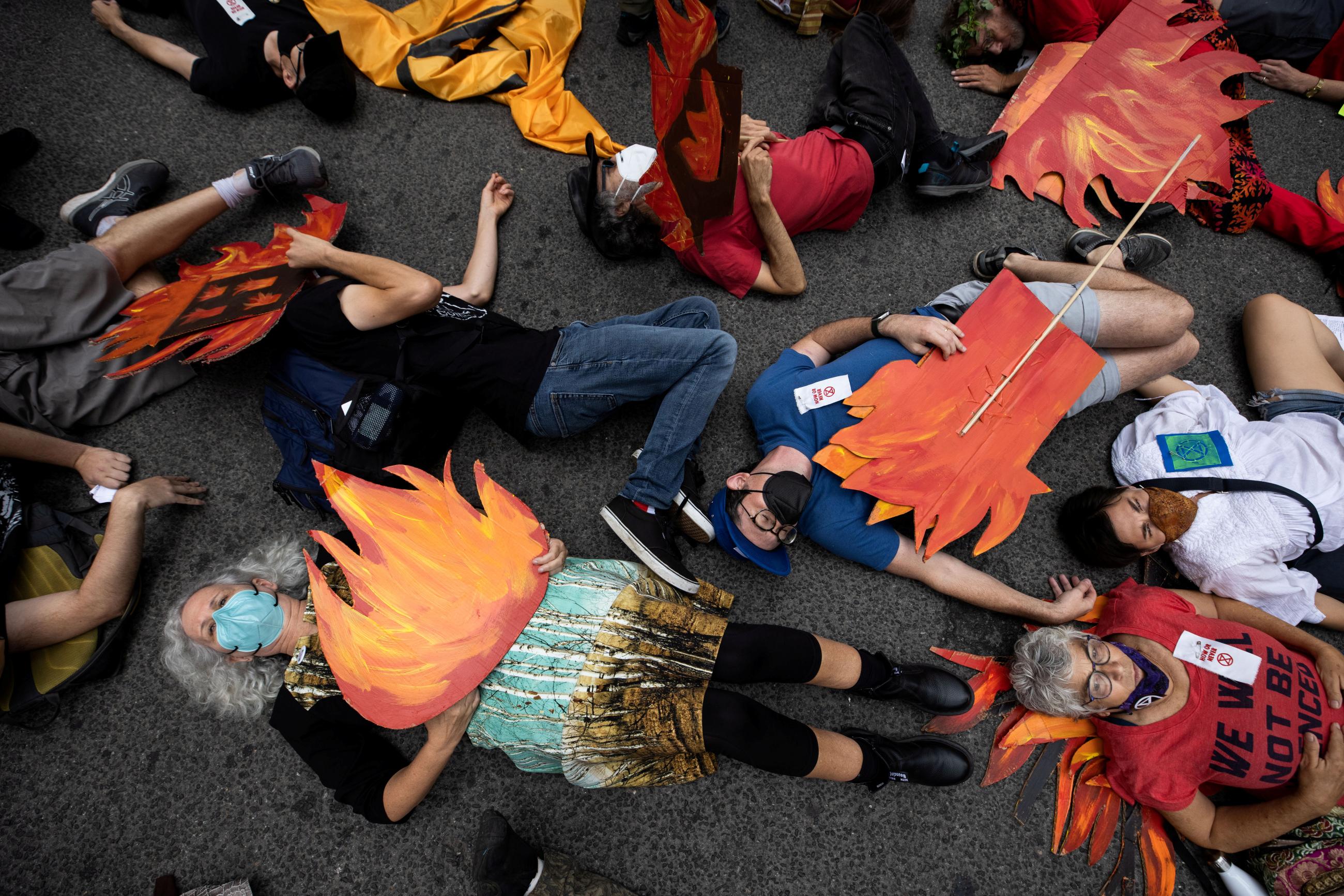 People block a street in Manhattan while pretending to be dead during a nonviolent resistance climate change protest organized by Extinction Rebellion in the Manhattan borough of New York City, on September 17, 2021.