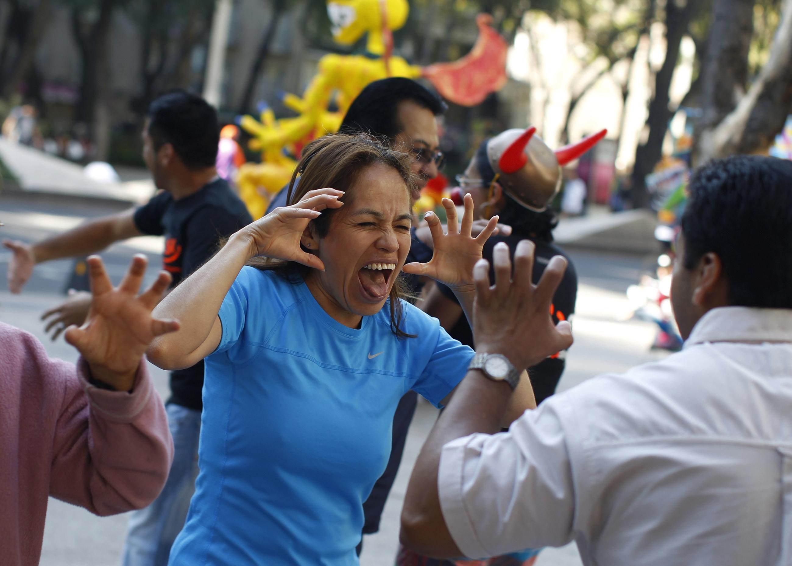 People gesture during a Yoga de la Risa (Laughter Yoga) session in Mexico City on October 21, 2012