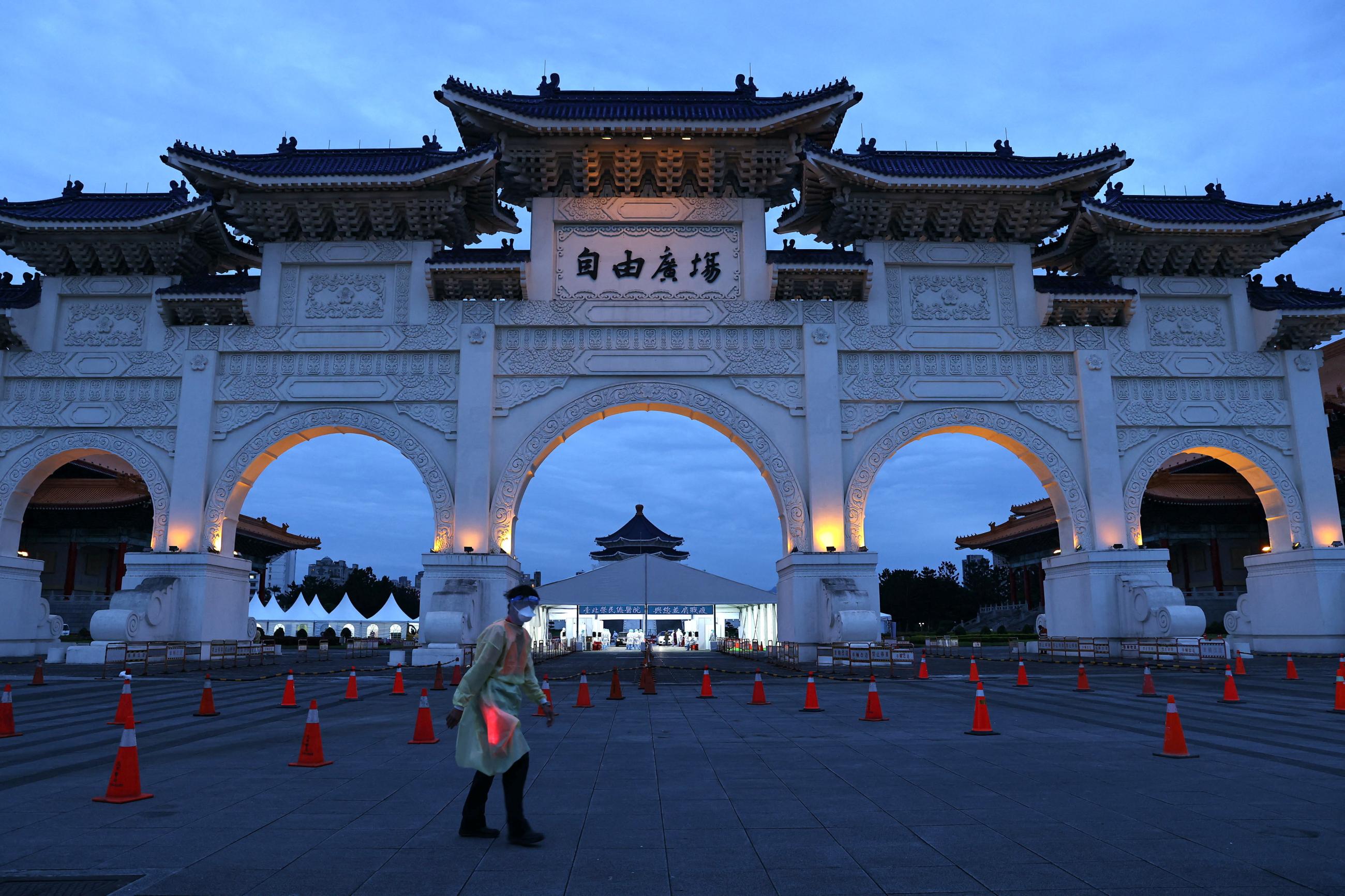 A medical worker in a protective suit walks past a newly set up coronavirus disease (COVID-19) test drive-through site at Liberty Square in Taipei, Taiwan, May 17, 2022. 