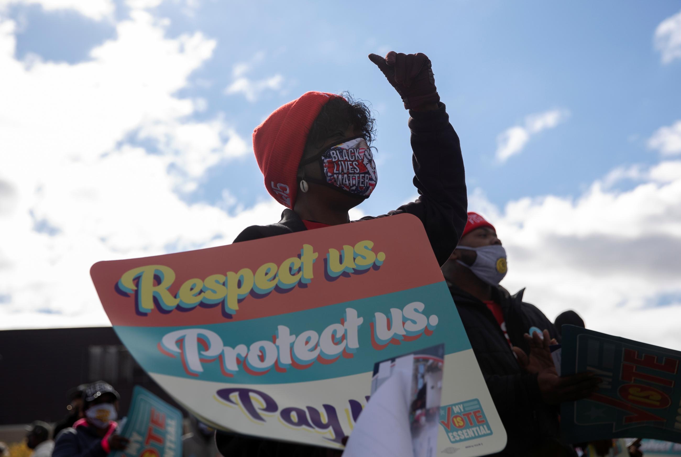 A woman cheers as she joins fast-food and nursing home workers as they gather during a "My Vote is Essential" rally before casting their early ballots, amid the coronavirus disease (COVID-19) concerns, at Wayne County Community College in Detroit, Michigan, U.S., October 24, 2020. 