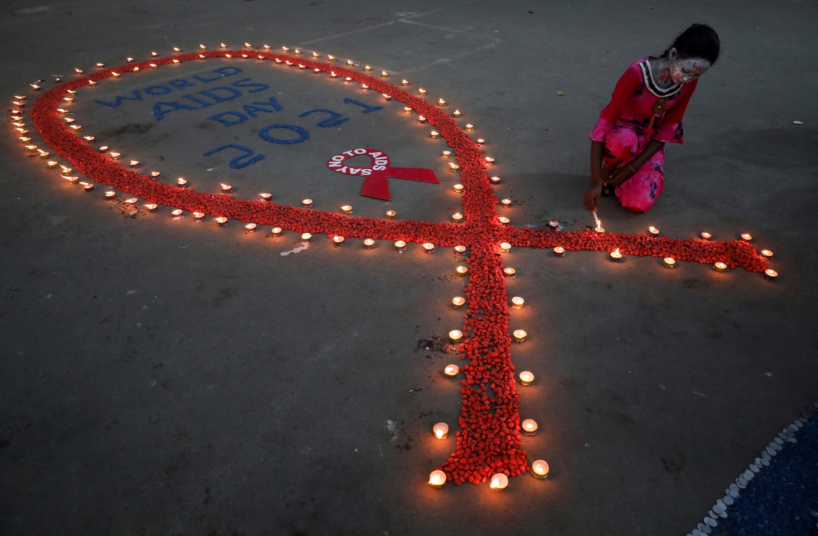 A girl lights earthen lamps during an HIV/AIDS awareness campaign on the occasion of World AIDS Day in Kolkata, India, December 1, 2021. 