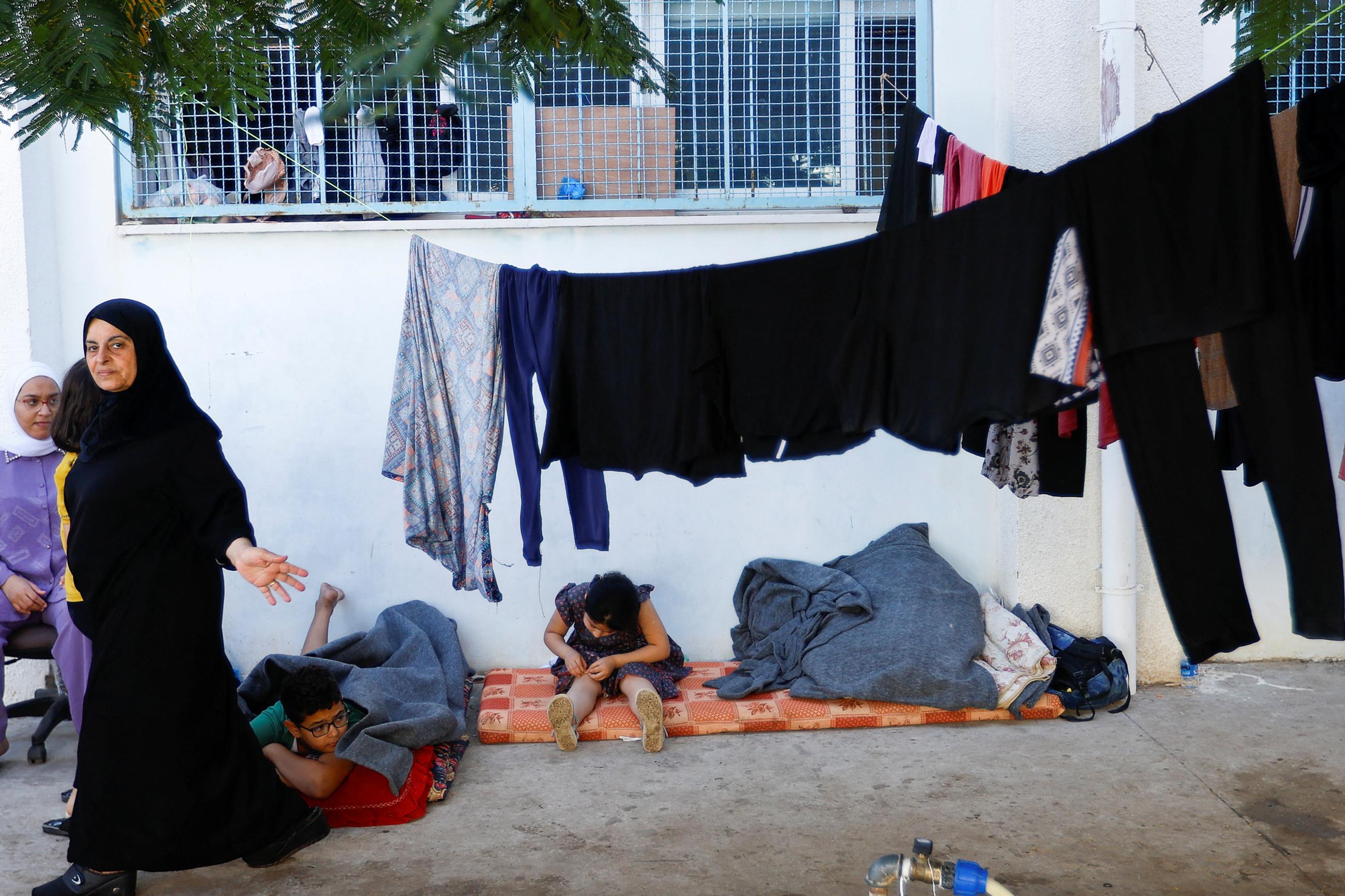 Palestinians, who fled their house amid Israeli strikes, shelter at a United Nations-run centre, after Israel's call for more than 1 million civilians in northern Gaza to move south, in Khan Younis in the southern Gaza Strip, October 18, 2023.