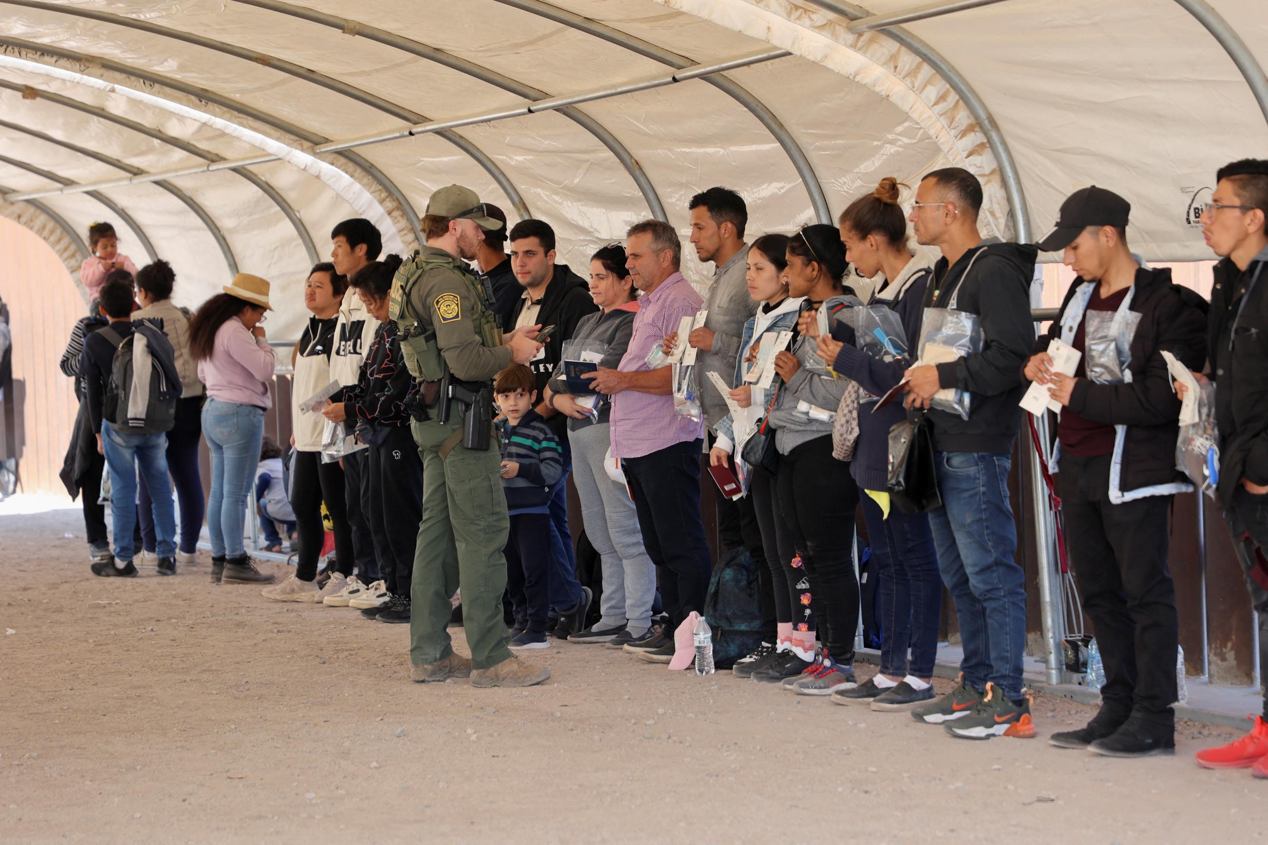 Border Patrol agents check documents of migrants who crossed the U.S.-Mexico border overnight.