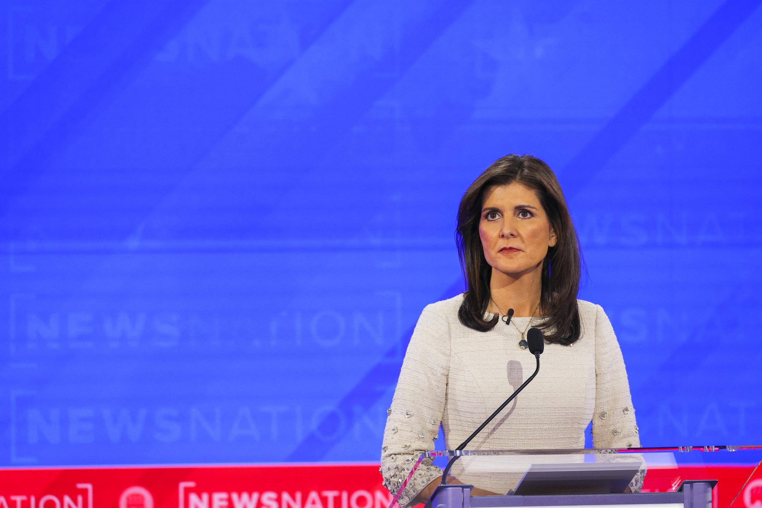 Republican presidential candidate Nikki Haley looks on.