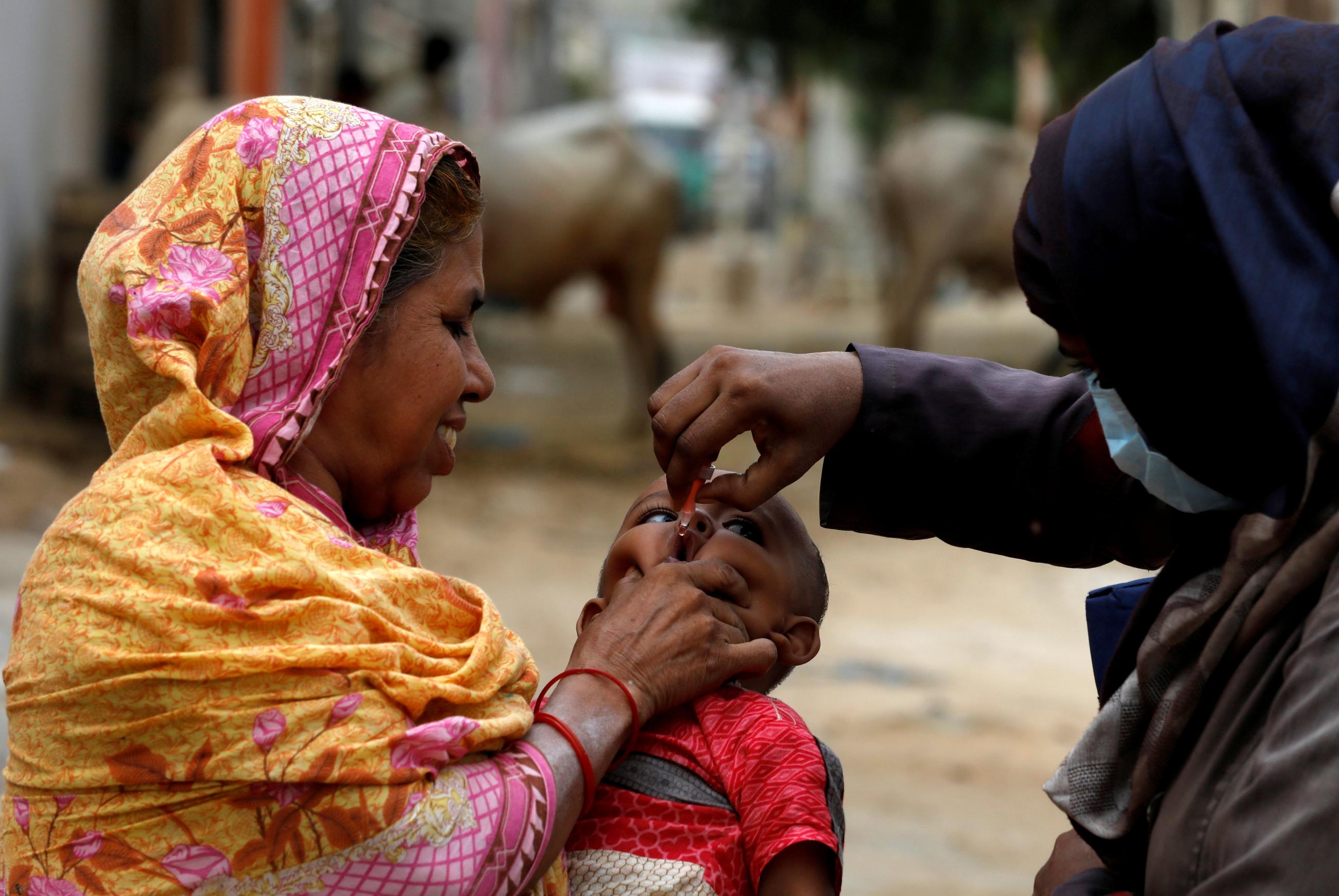 A boy receives polio vaccine drops, during an anti-polio campaign, in a low-income neighborhood.