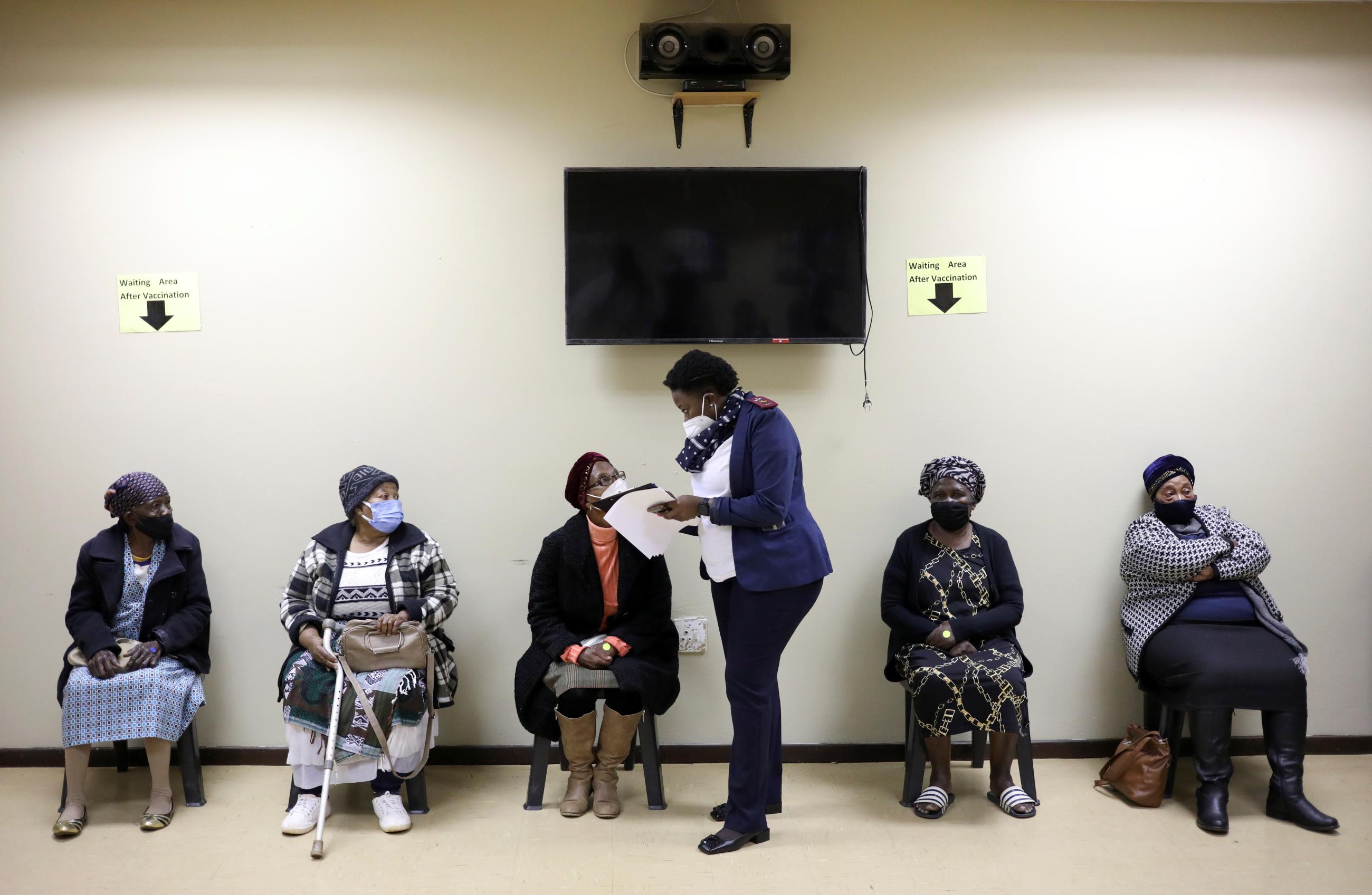 A nurse talks to a woman following her vaccination.