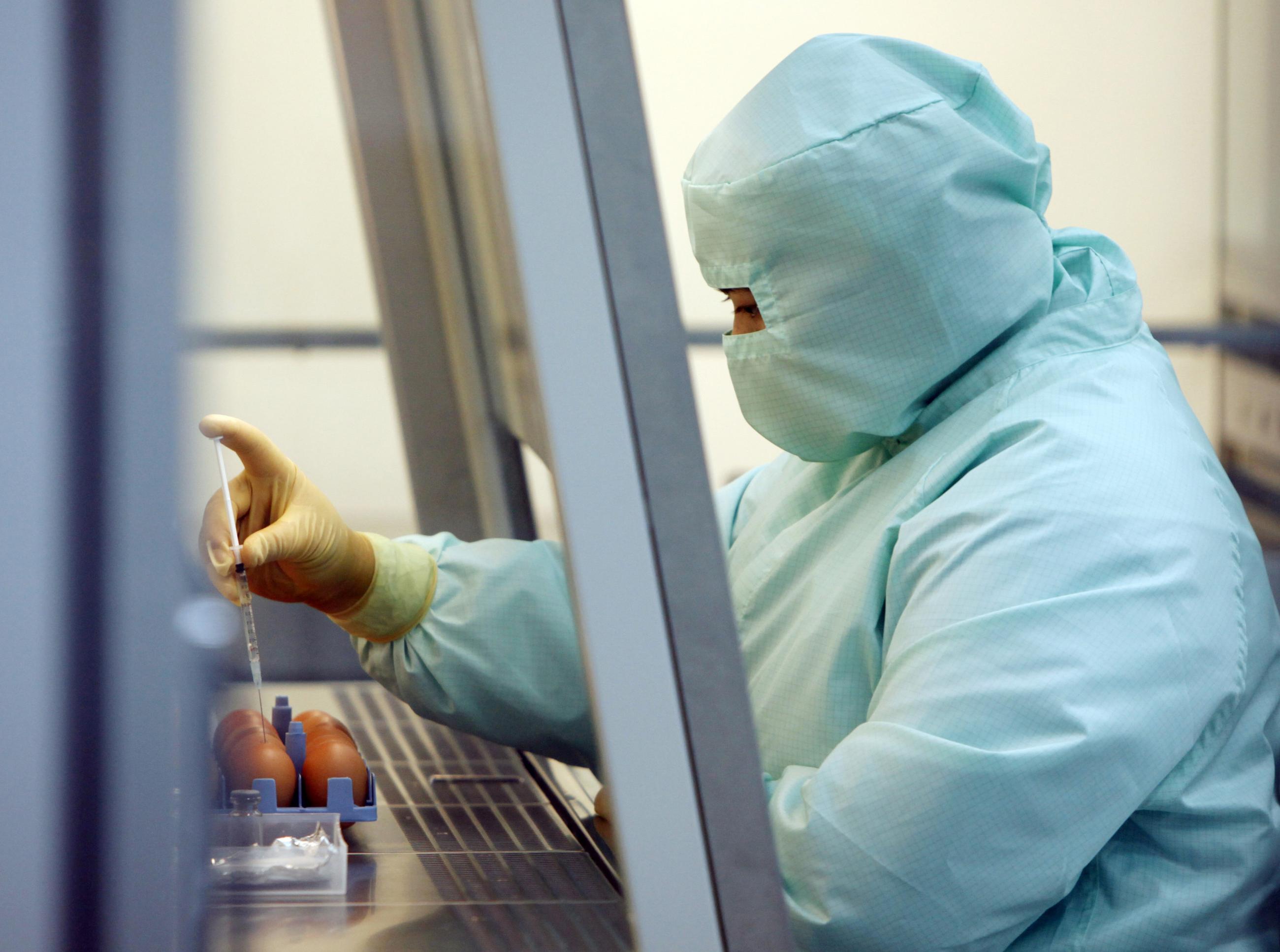 A scientist works on developing the H1N1 (Influenza A) vaccine inside a biosafety level 3 (BSL-3) lab.
