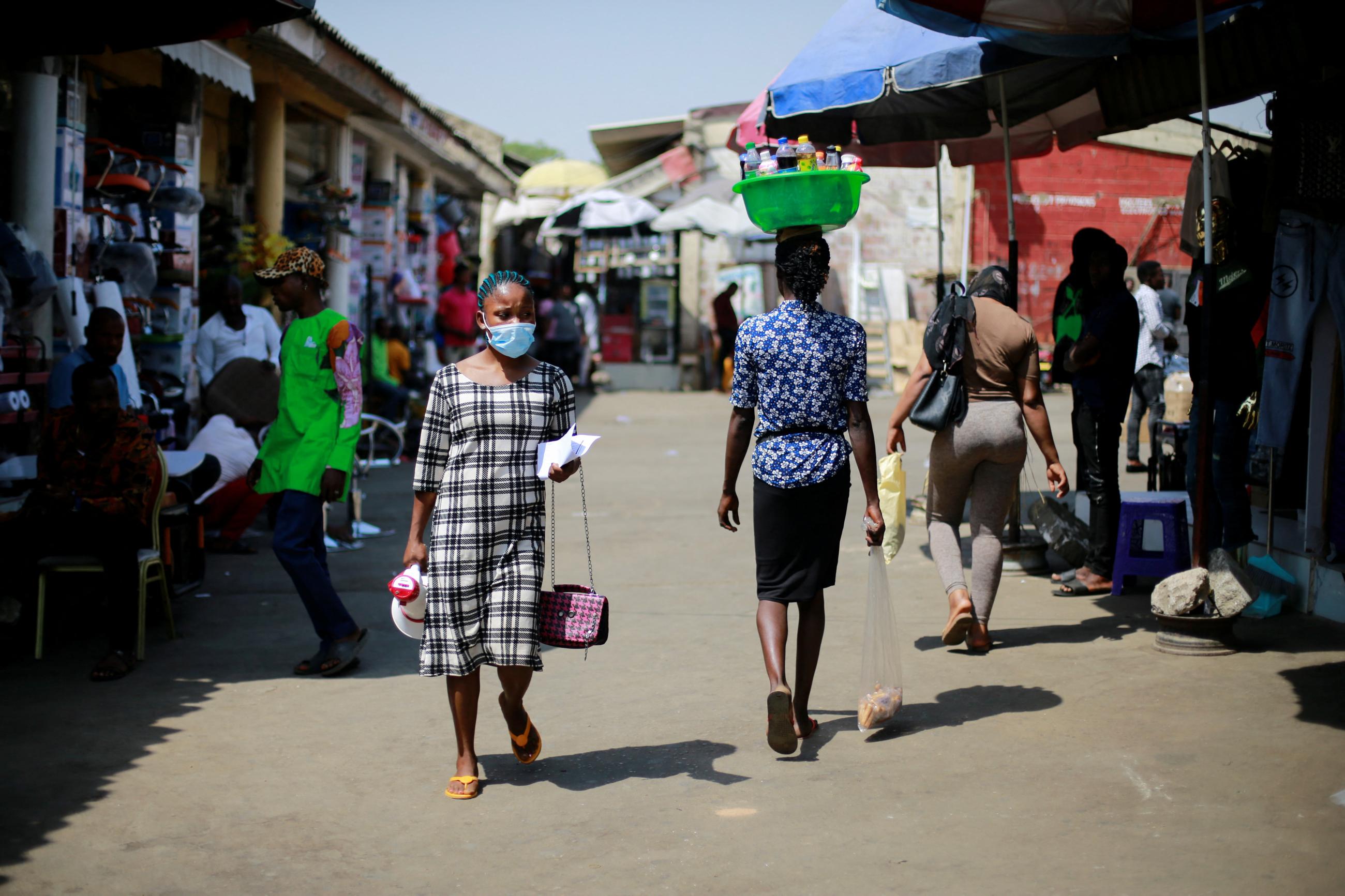 A woman calls out to people for vaccination during a COVID-19 mass vaccination exercise.