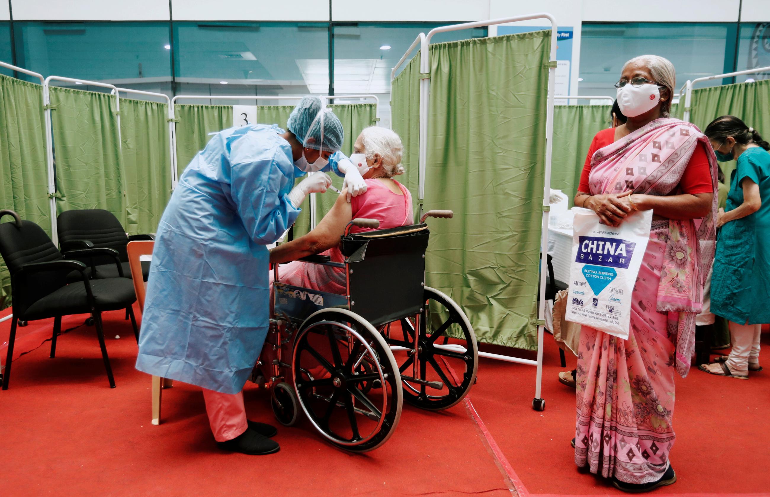 A woman on a wheelchair receives a dose of COVISHIELD, a COVID-19 vaccine manufactured by Serum Institute of India.